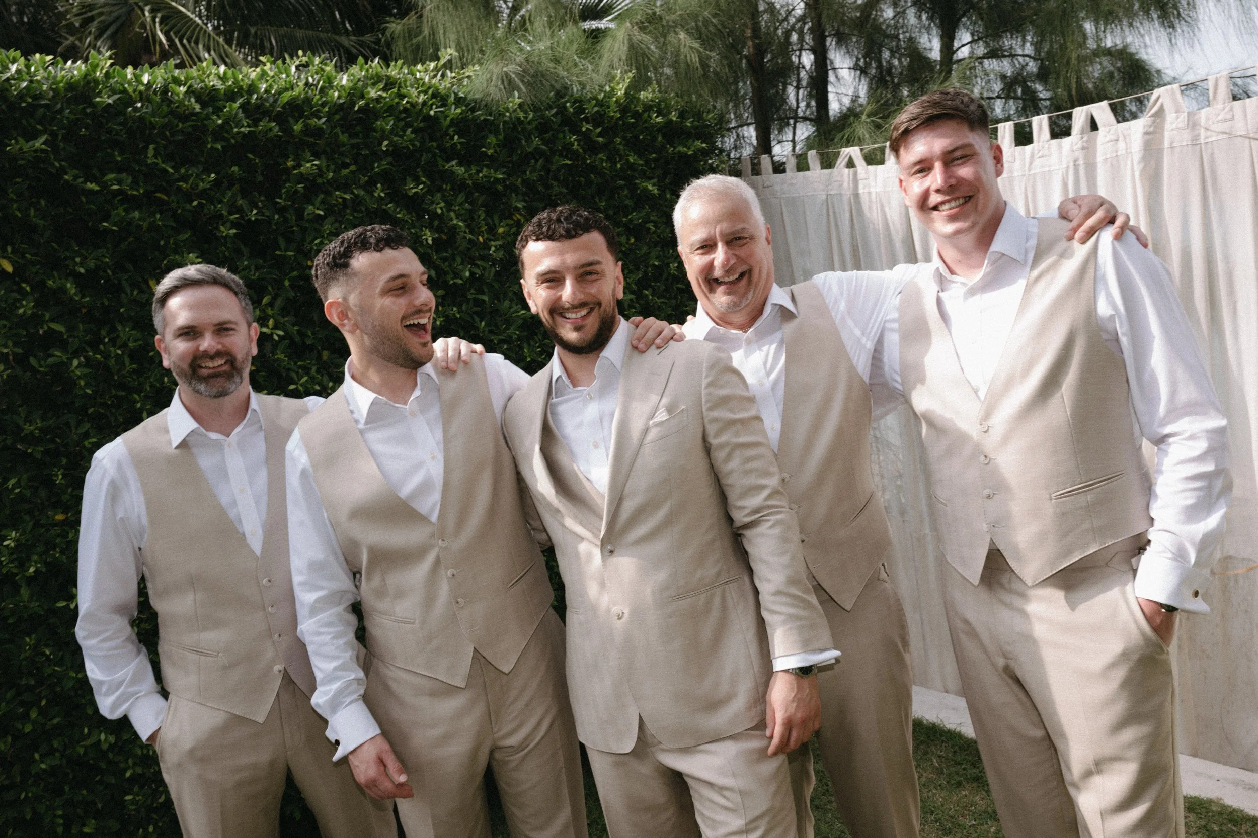 groom wedding party dressed in white shirts and linen suits before ceremony
