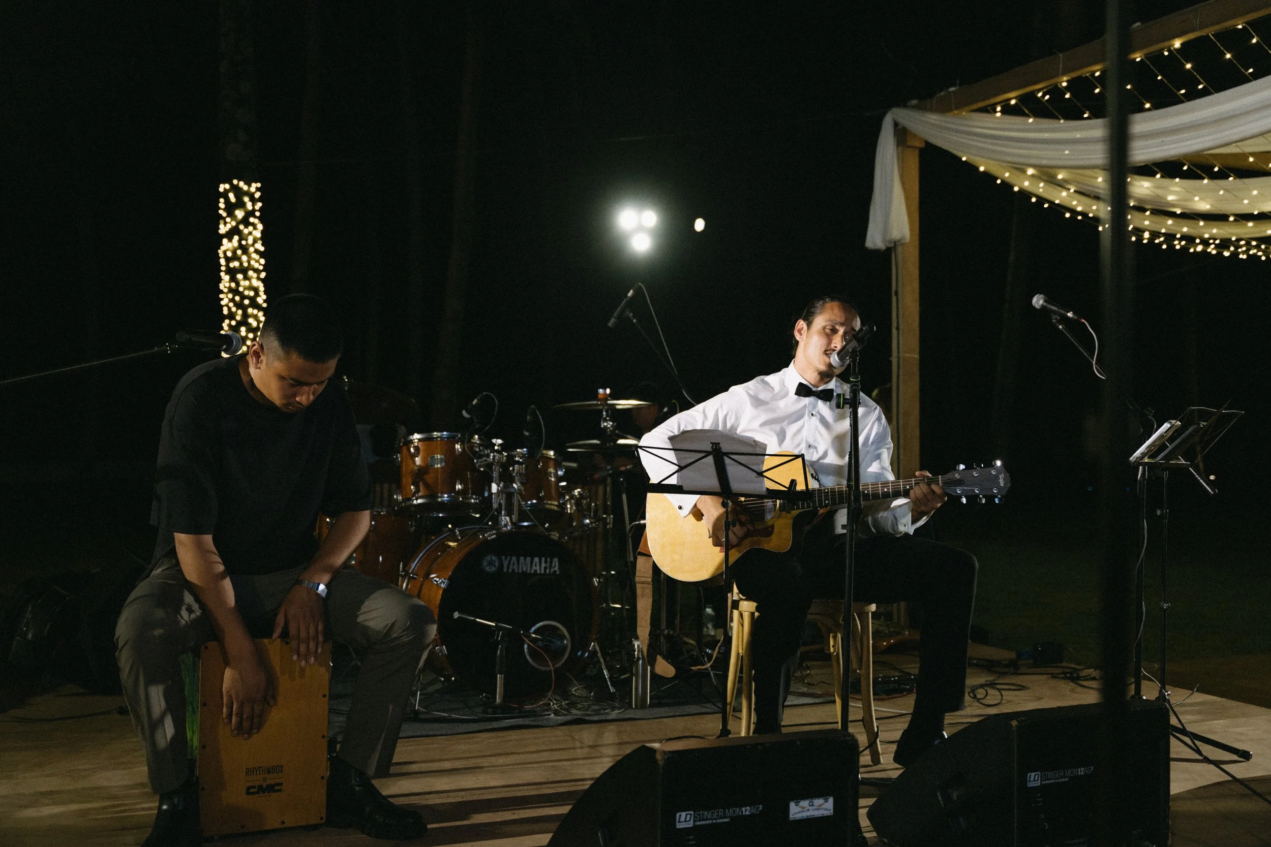 groom singing and playing guitar during surprise performance at wedding reception