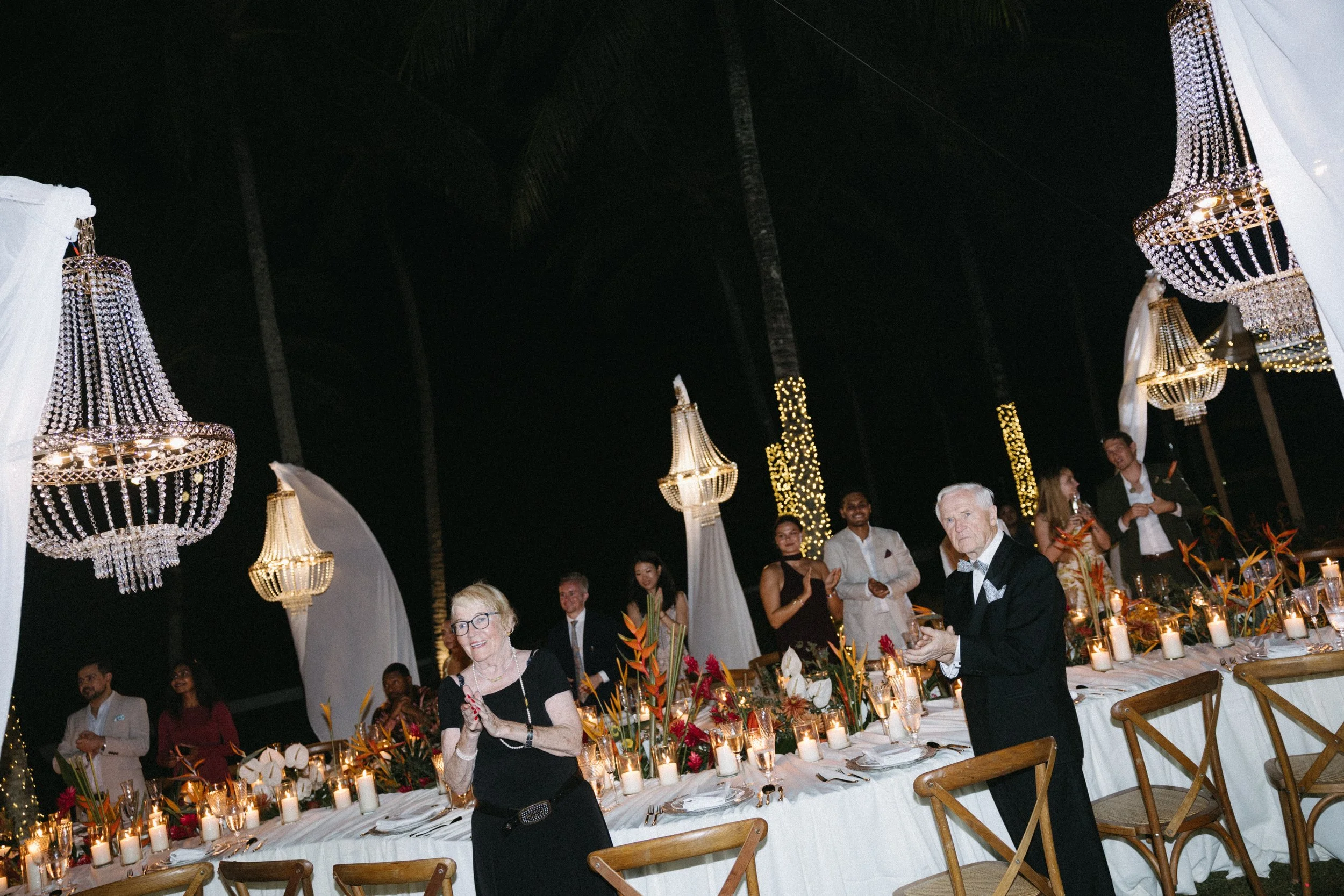 candid shot of guests standing and clapping as wedding reception begins