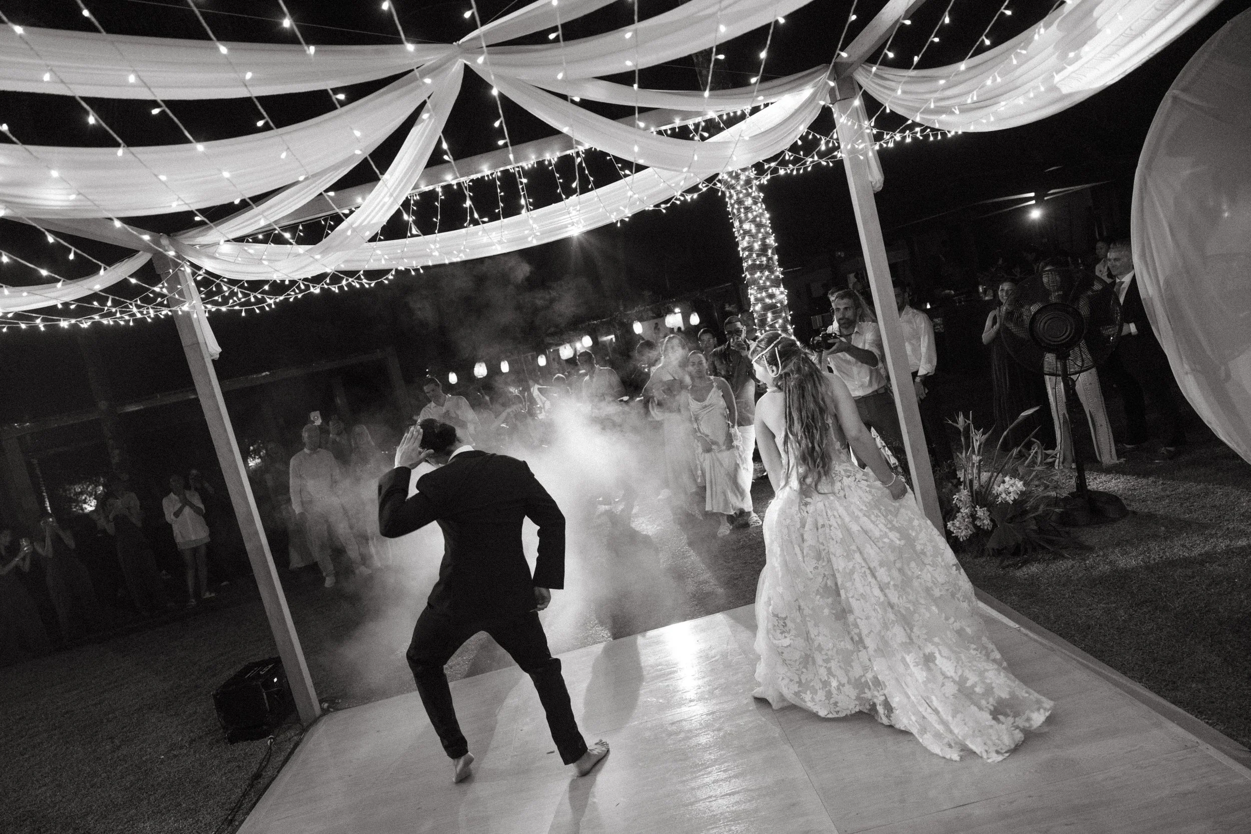 couple's first dance with guests onlooking during outdoor destination wedding reception