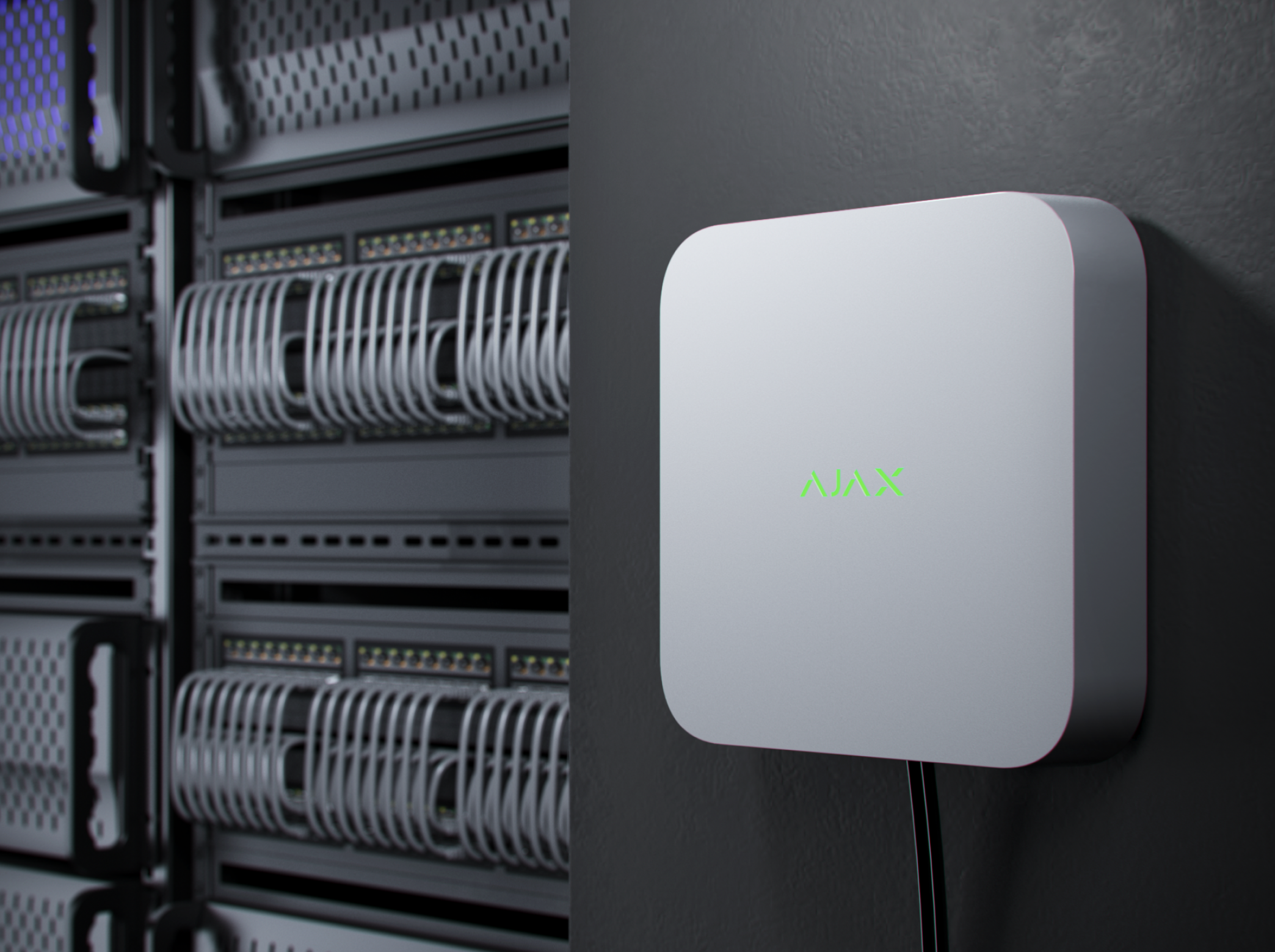 Close-up of a white wall-mounted device with green text 'AJAX' on it, mounted next to a server rack with network hardware and cables. part of a Complete Fire and Security System in Southampton, Hampshire.