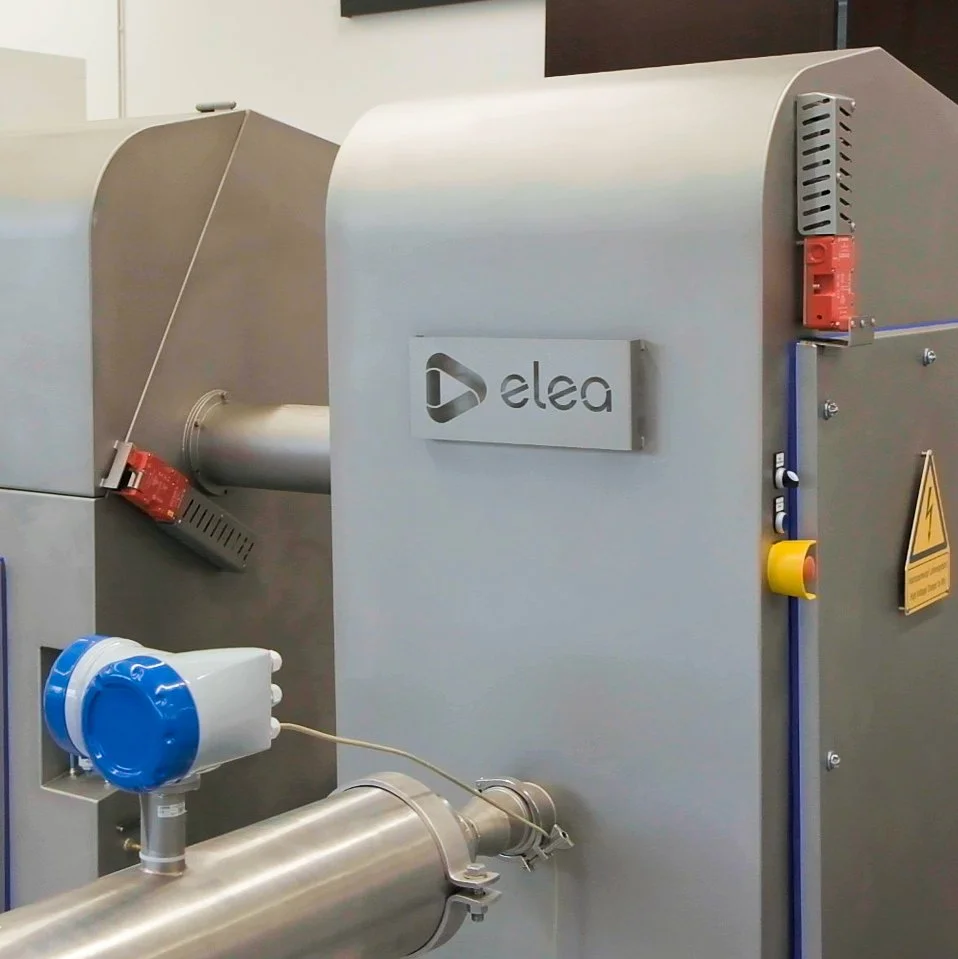 Industrial equipment with Elea logo and warning signs, featuring metal pipes and electrical components.