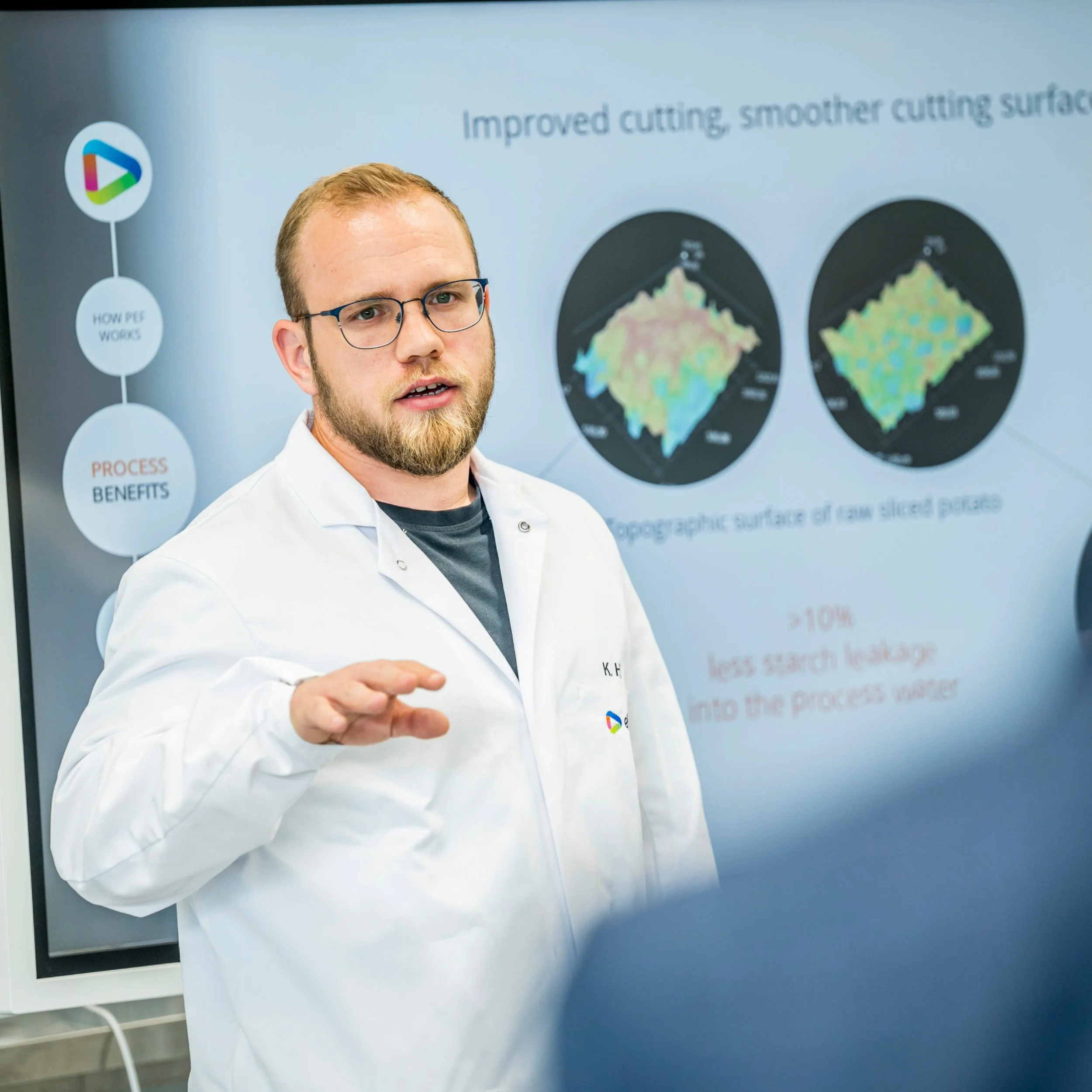 Industrial food processing equipment with worker in protective gear in a factory setting.