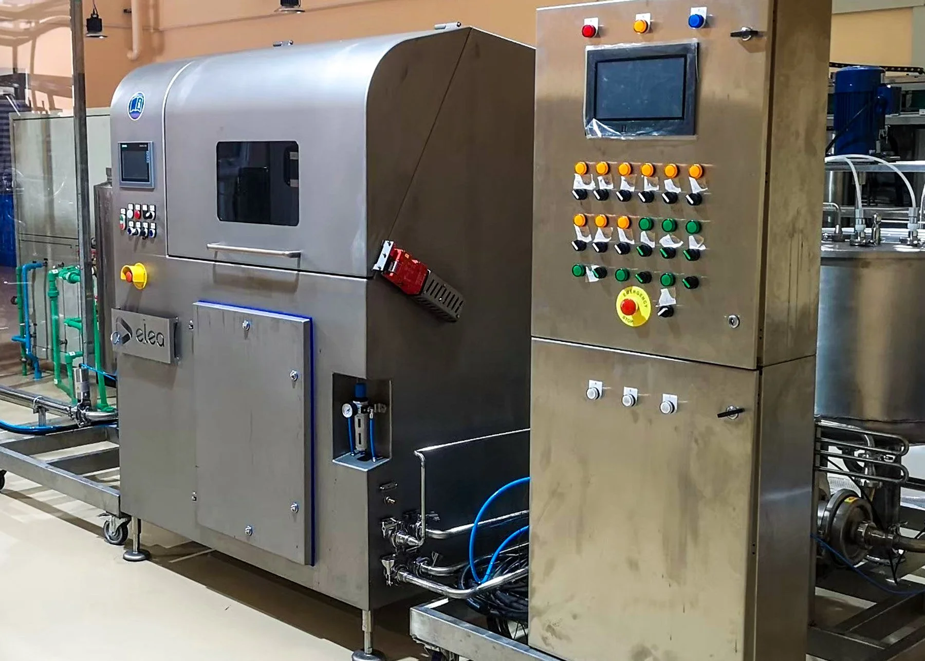 Industrial machine with control panel, buttons, and display in a factory setting.