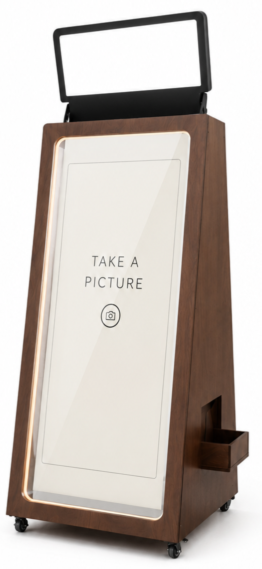 A wooden digital kiosk with a blank, illuminated screen frame on top and a large interactive display below displaying the message "Take a Picture" with a camera icon.