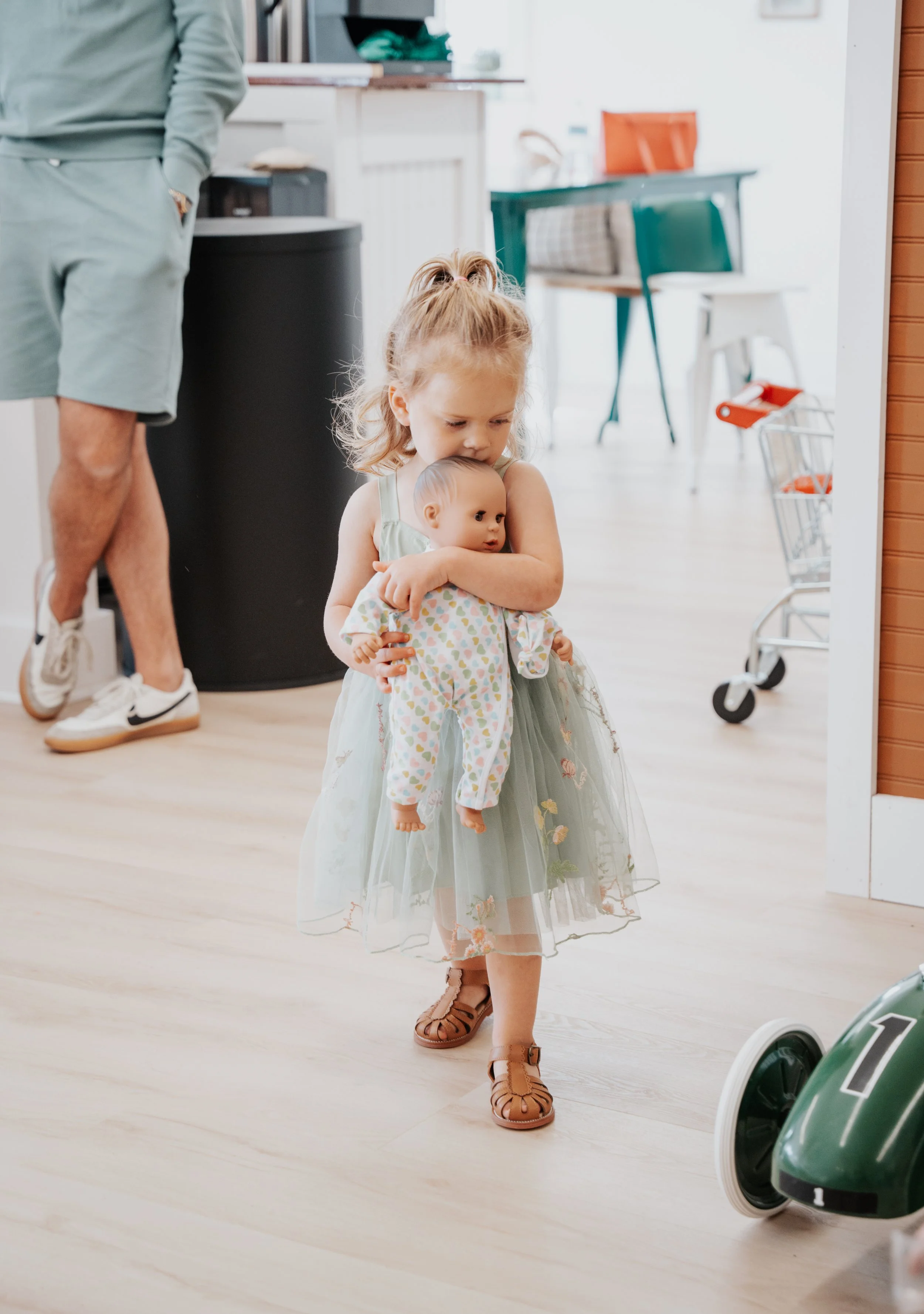 Child holding baby doll and playing