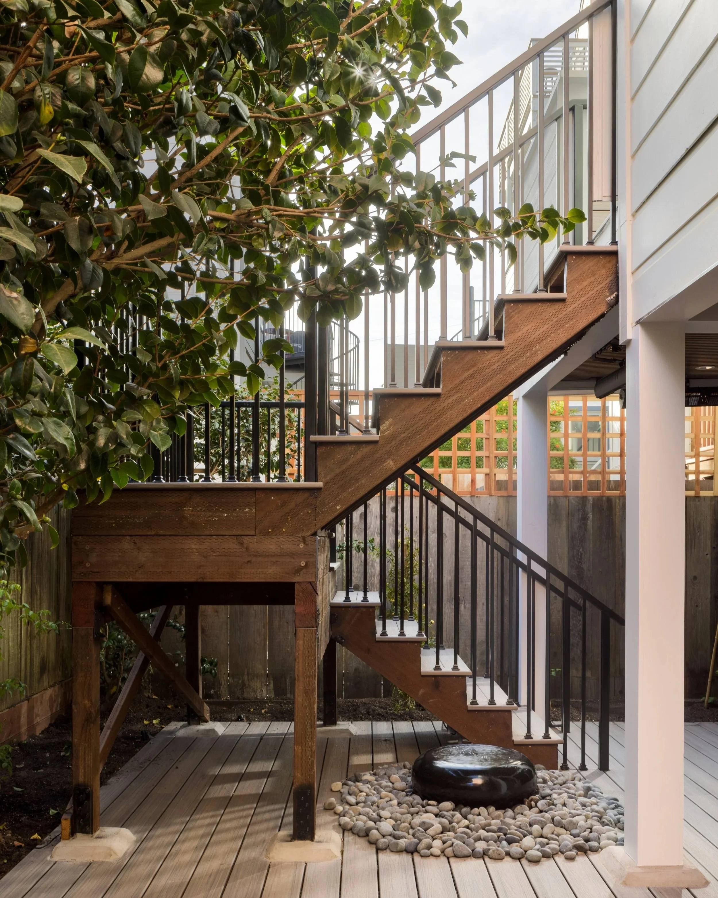 A San Francisco home renovation featuring a custom rear yard deck, landscaped garden, and new staircase that seamlessly connects the basement to the outdoors.