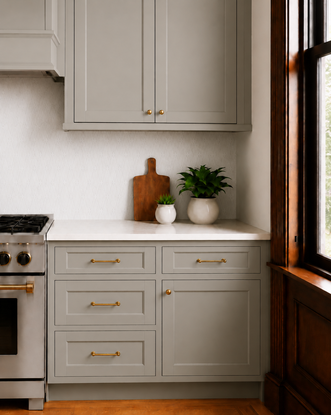 A refined NYC Brooklyn kitchen renovation by From David Designs, featuring sage green cabinetry, a marble island, brass lighting, restored wood trim, herringbone floors, and a warm transitional interior aesthetic.