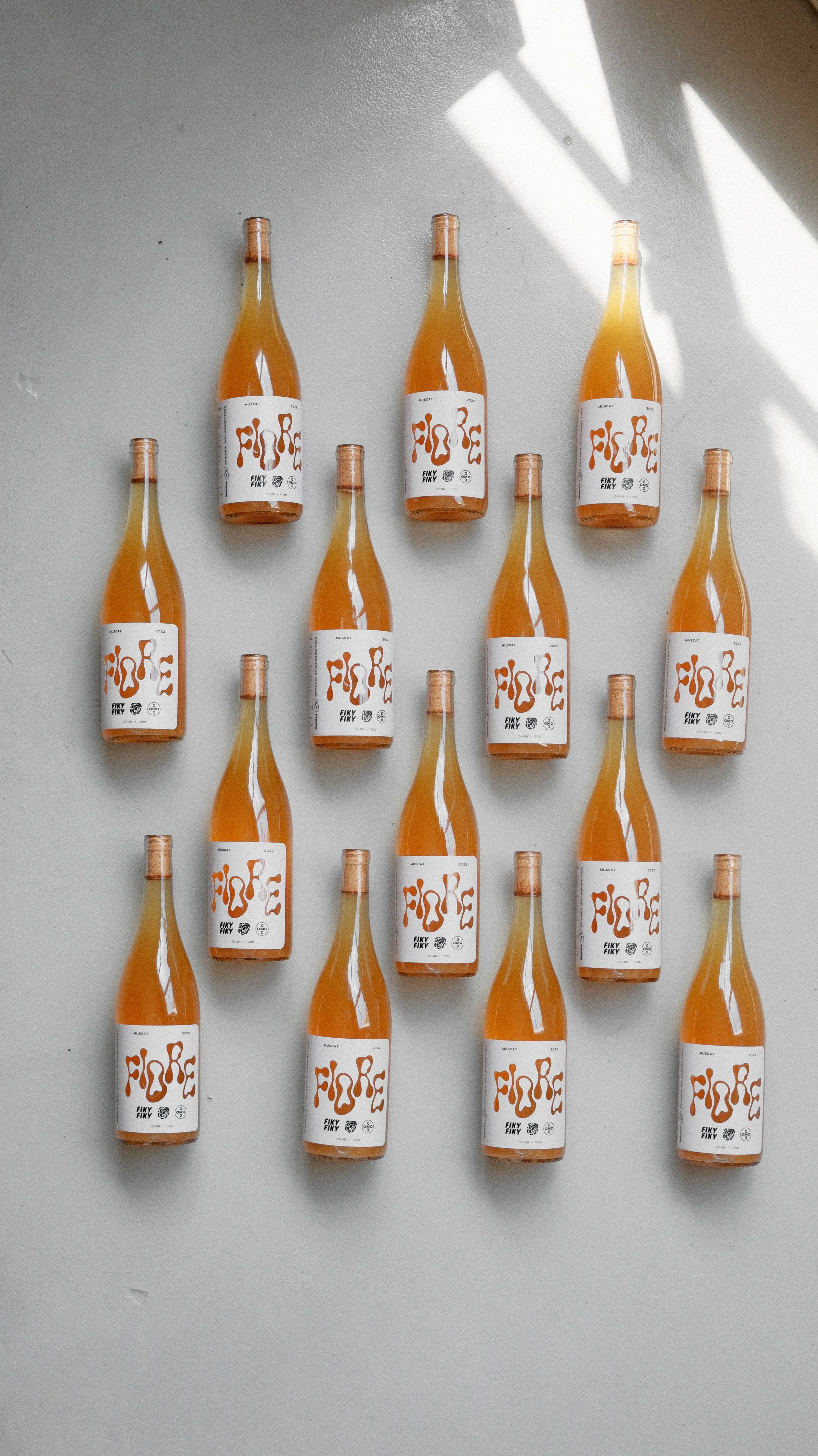 Row of natural orange wine bottles at Omo Mercado