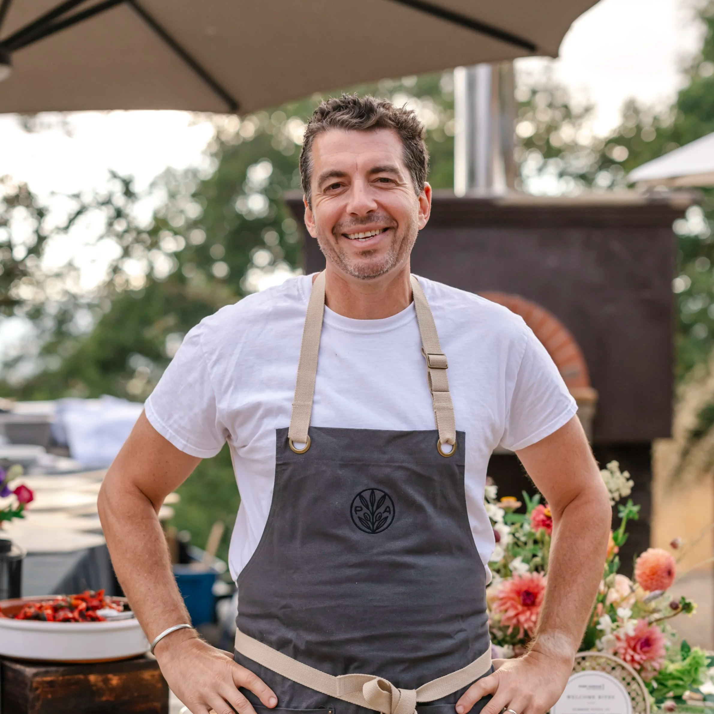 Chef Ari Weiswasser posing for a photo in front of the Paradise Ridge pizza oven.