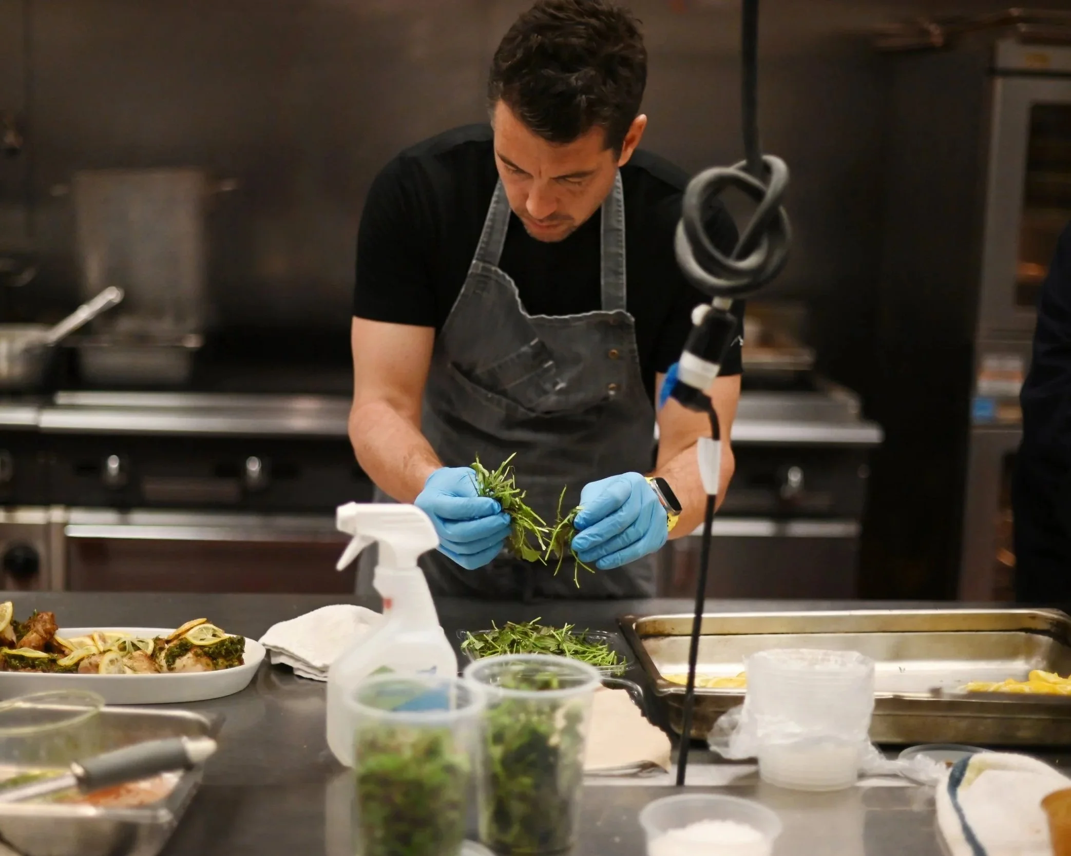 Chef Ari plating a family style entree during an event.