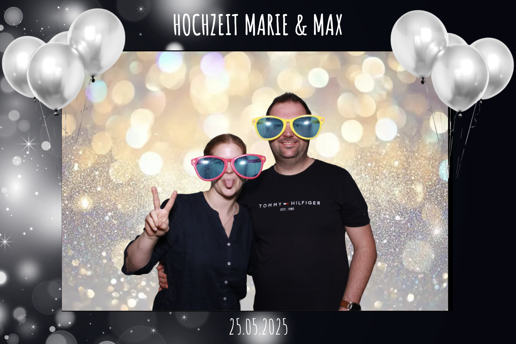 Ein Paar bei einer Hochzeit am 25. Mai 2025, das spaßige Sonnenbrillen trägt, in einem Fotohintergrund mit Glitzer- und Blasen-Design, mit weißen Luftballons auf beiden Seiten.