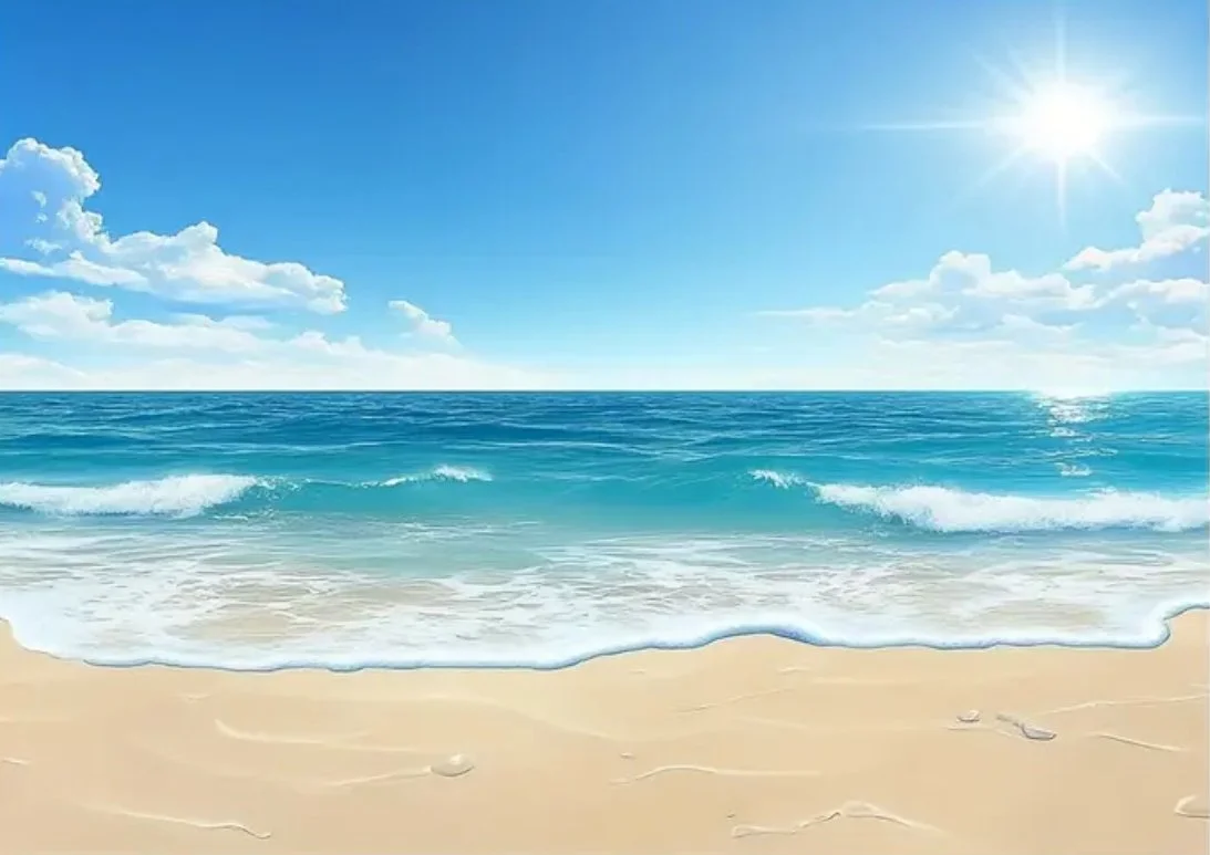 Sonniger Sandstrand mit blauem Meer und Himmel, wenige Wolken, Sonne strahlt am Himmel, Wellen rollen ans Ufer.