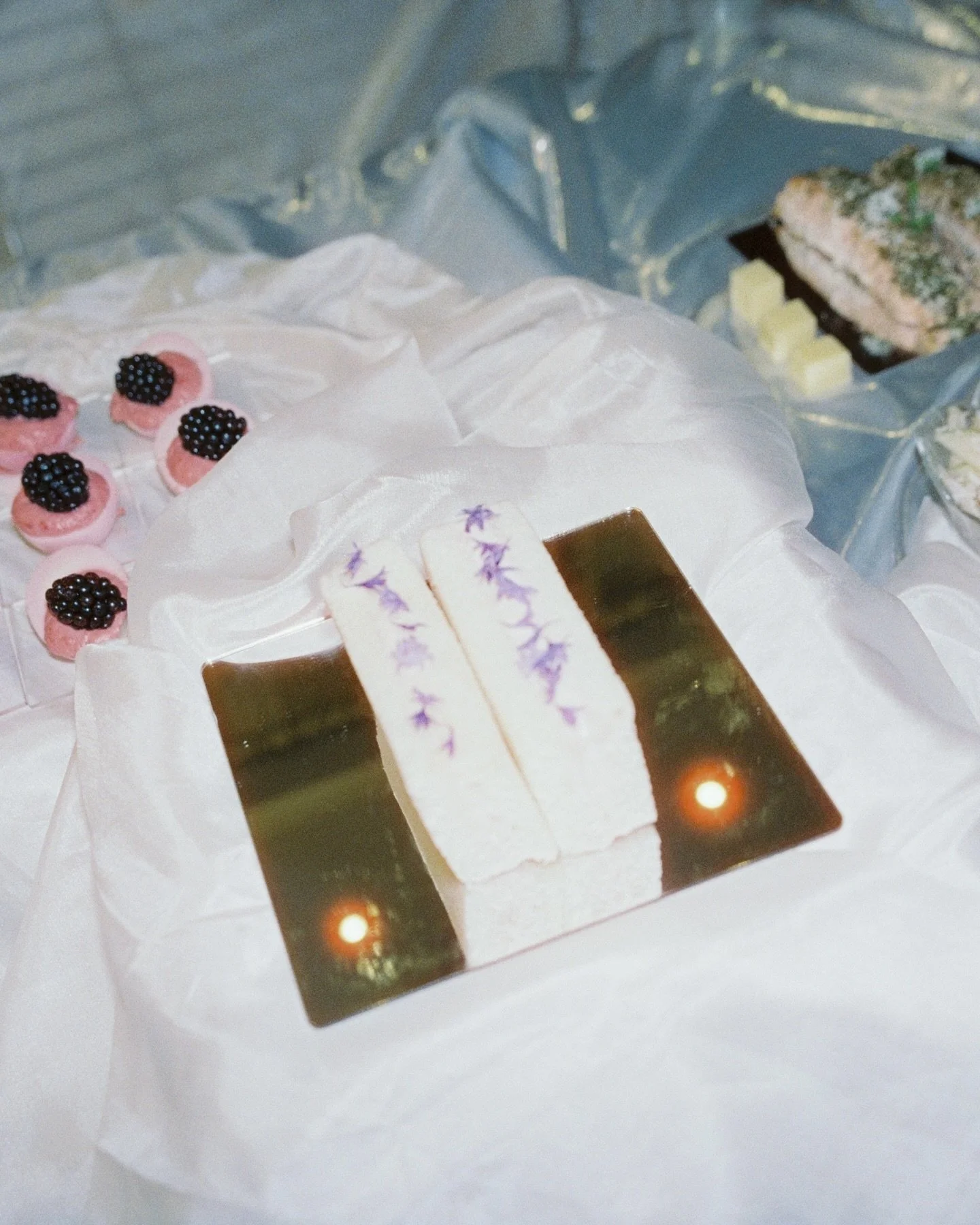 the brief was portals ~ something otherworldly

a grazing table, but reinvented: mirrors + reflective surfaces, molten metallic draping + chandeliers glowing like another dimension (thanks candida 800).

bridal but not traditional 
~ intentional ~ el