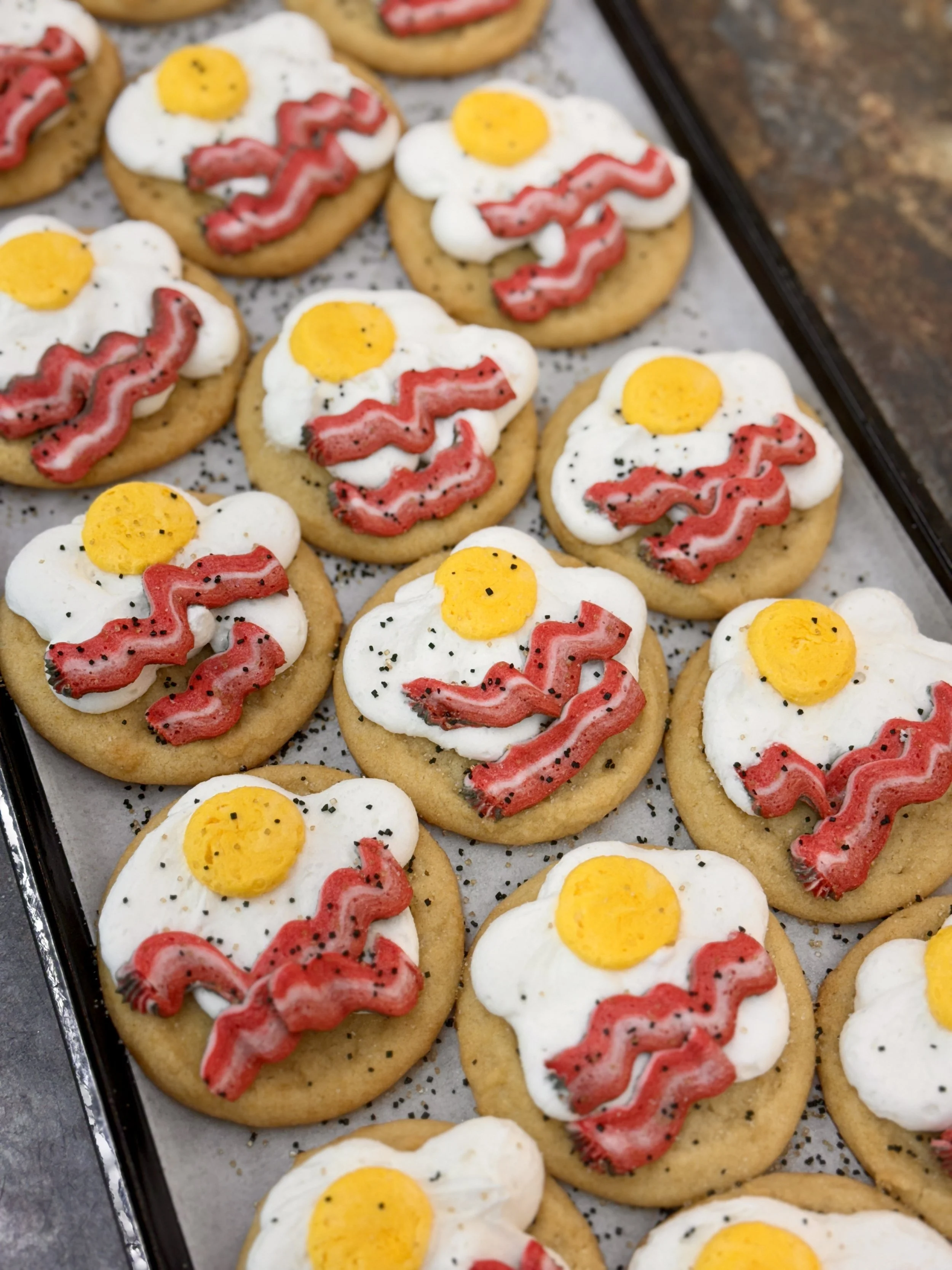 Baked cookies decorated to look like fried eggs on a baking sheet.