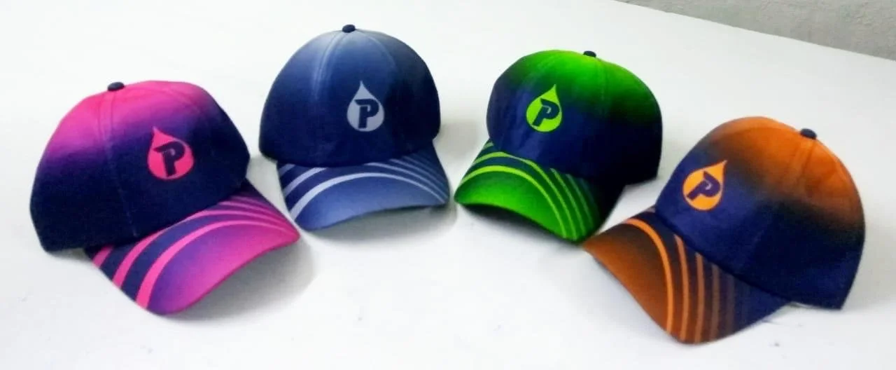 Four colorful baseball caps with varying shades of pink, blue, green, and orange, each featuring a logo with a pencil shape and the letter "P."