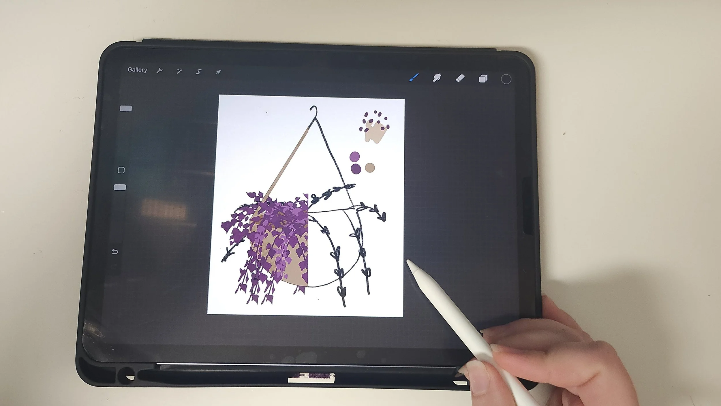 Artist drawing a hanging planter illustration on a tablet with a stylus