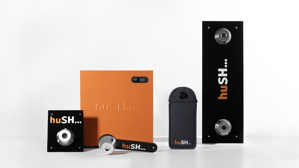 Collection of portable speakers, a portable projector, and carrying case with the brand "huSH..." on a white background.