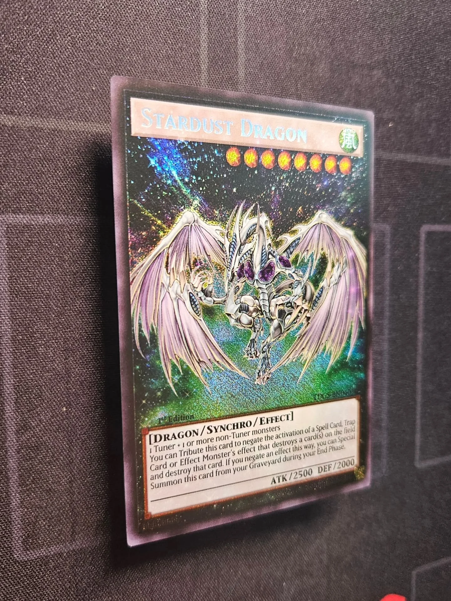 Stardust Dragon is our first Extended Art synchro monster and it's a head turner! The white dragon and text boxes on the otherwise dark background provide a high contrast that pops extra loud when the "secret" foil hits.

This makes Day 8 o