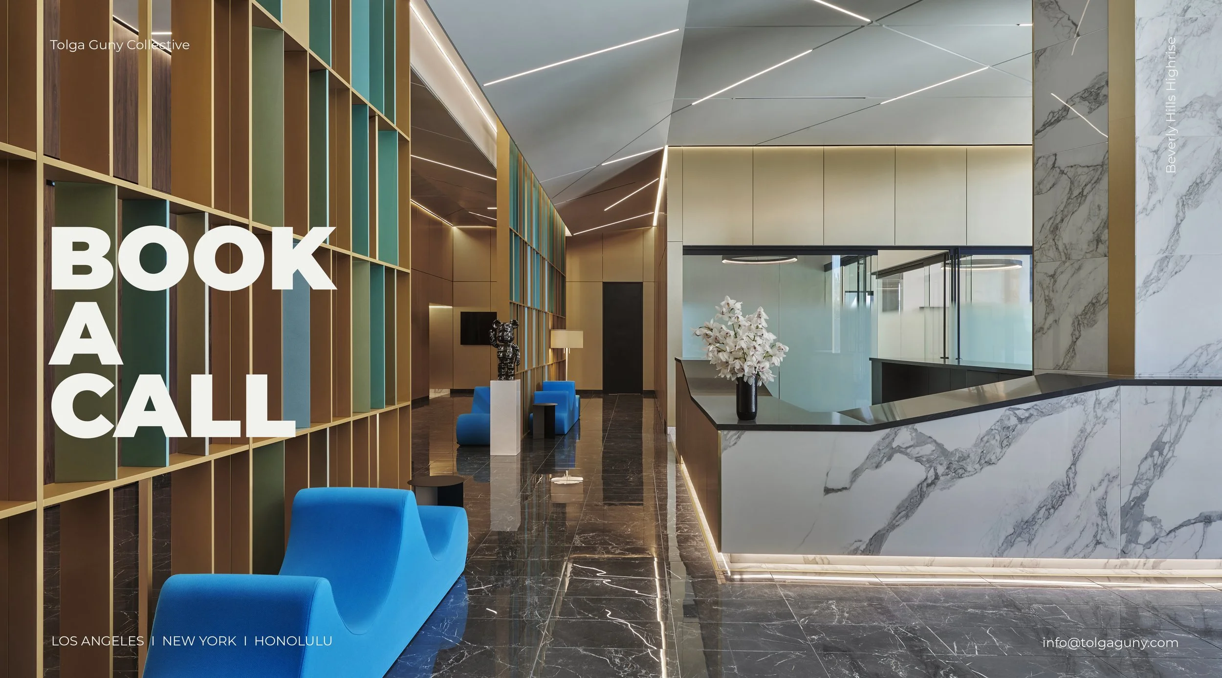 Modern hotel lobby with black marble floors, colorful library-style shelves on the left, and a marble reception desk on the right. Bright blue chairs and a black side table are visible in the seating area. Elegant lighting and decor accents create a sleek, contemporary ambiance.