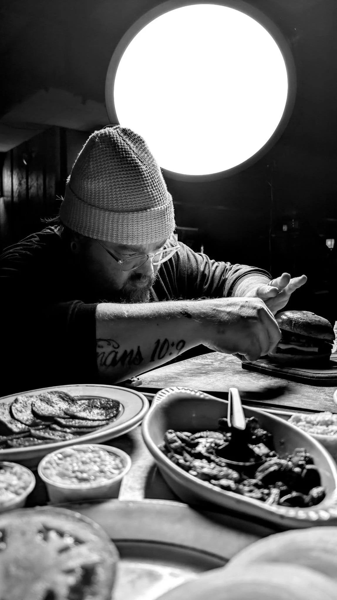 Behind-the-scenes food photography shoot in a working kitchen near Chicago, with a photographer styling a burger under studio lighting for restaurant branding.