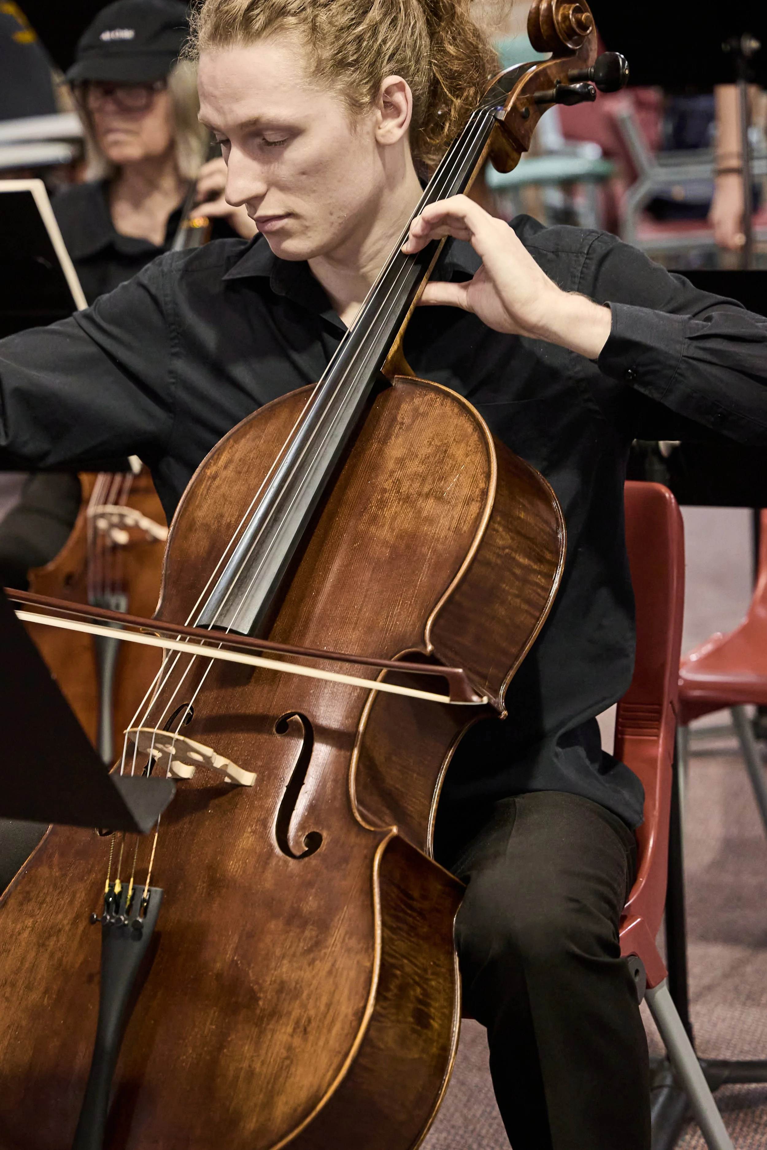 male orchestra member plays cello