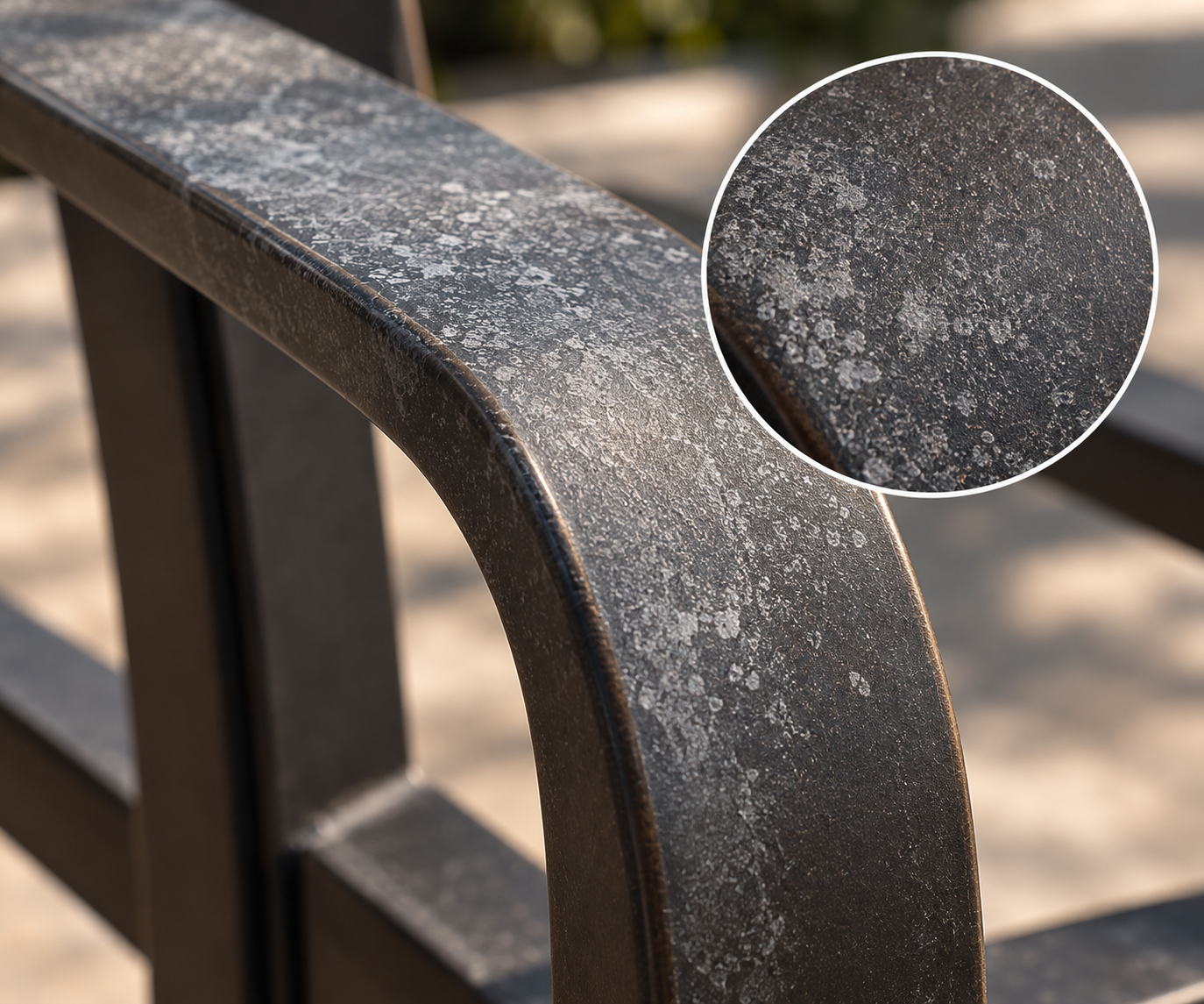 Close-up of a black metal park bench with a Chalky  surface.