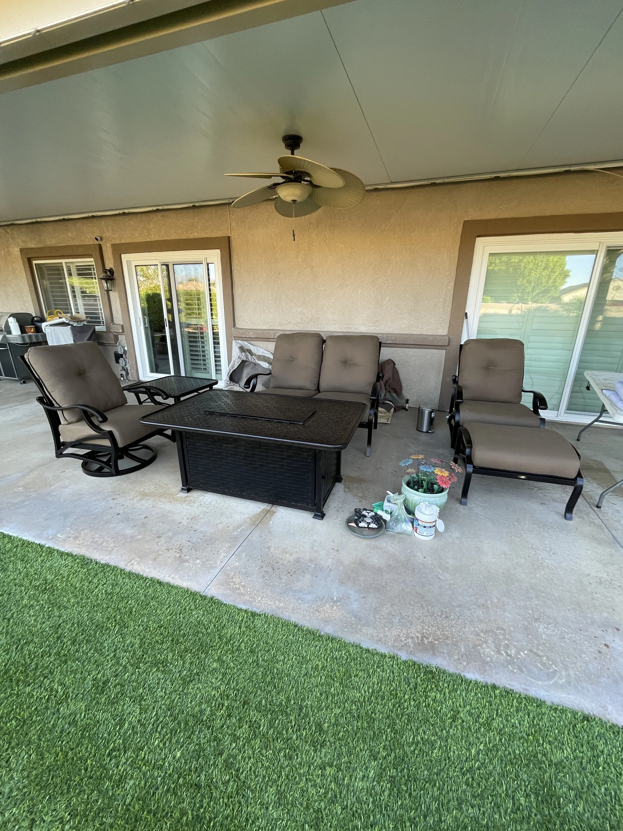 Back porch area with outdoor furniture, patio door, sliding door, and artificial grass.