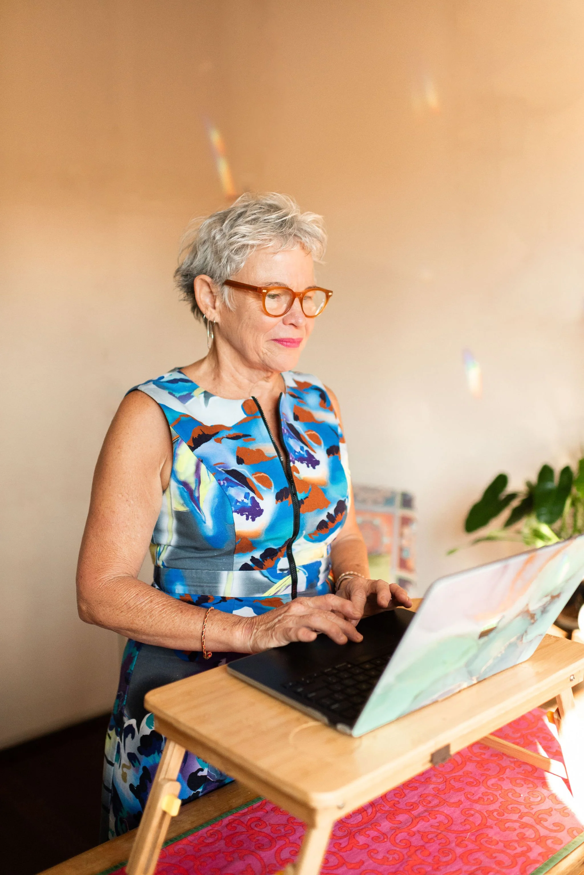 Brownyn Clee, CEO of The Institute of Hope, stands at a laptop editing the podcast, feeling safe and standing strong.