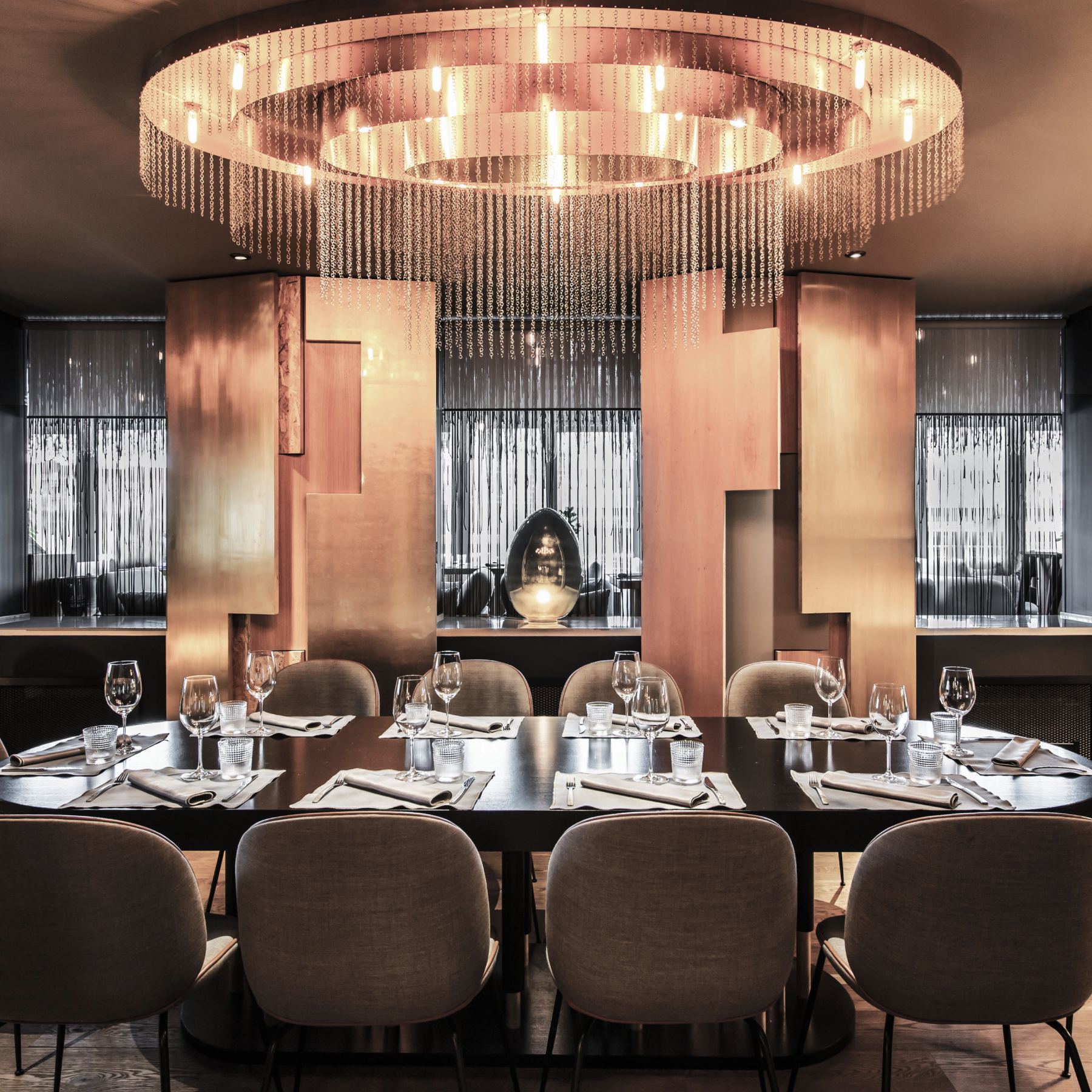 Elegant dining room with modern chandelier, set dinner table, and contemporary decor.