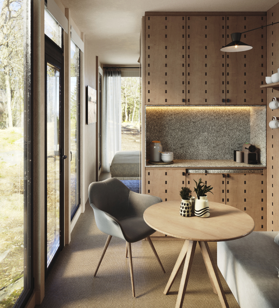 Modern studio interior with kitchenette, dining table, and armchair