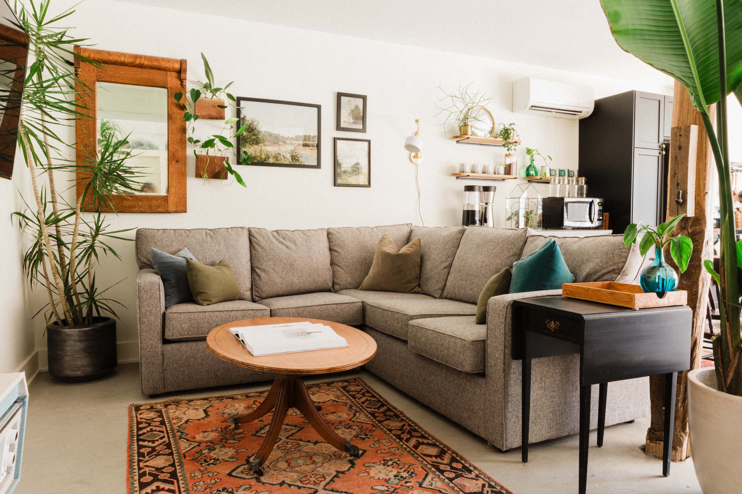 Boho living room with sectional  sofa 
Kilim rug, and vintage coffee table.