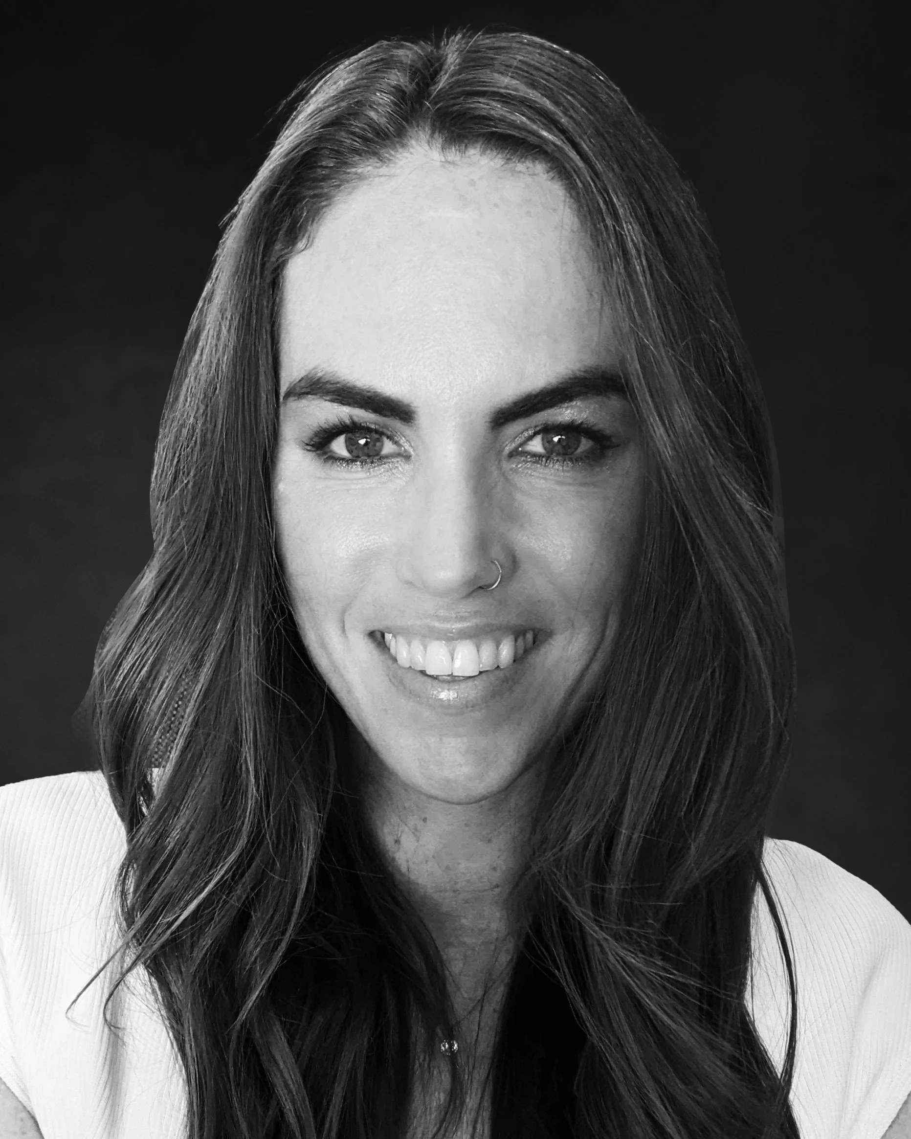 Black and white portrait of Cathy Macguinness, Head of Operations Airspeeder with long hair smiling at the camera