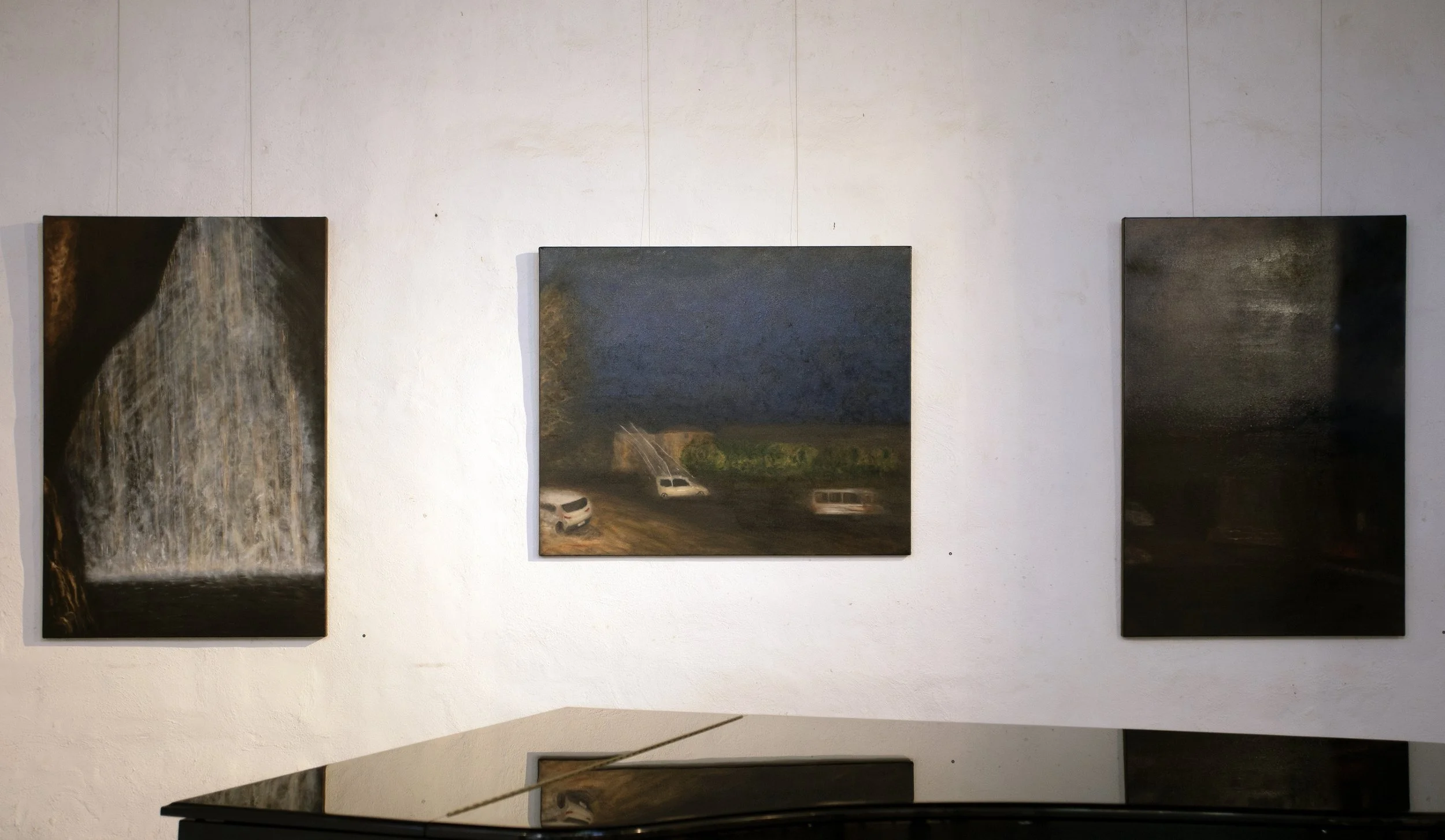 Three Landscape Paintings Displayed on a White Wall in an Art Gallery