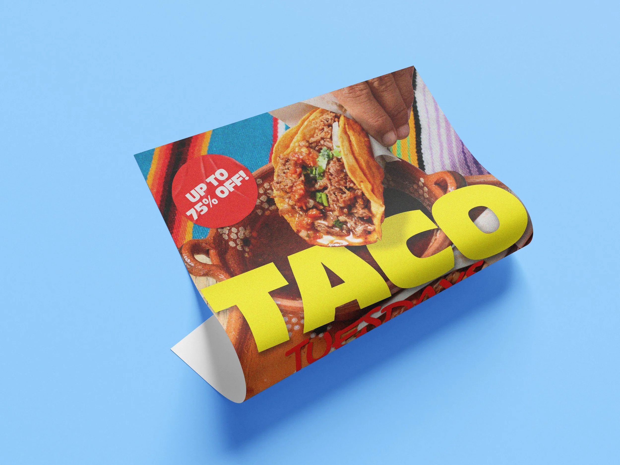 A folded poster with the word "taco" in bright yellow text, and an image of someone dunking a taco in some sauce in the background.