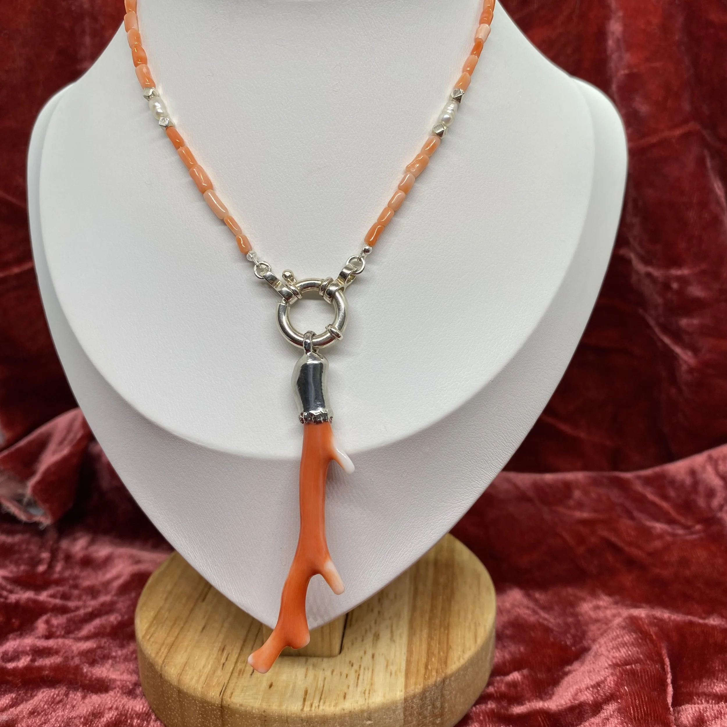shot of coralie necklace on white mannequin with pink velvet backdrop