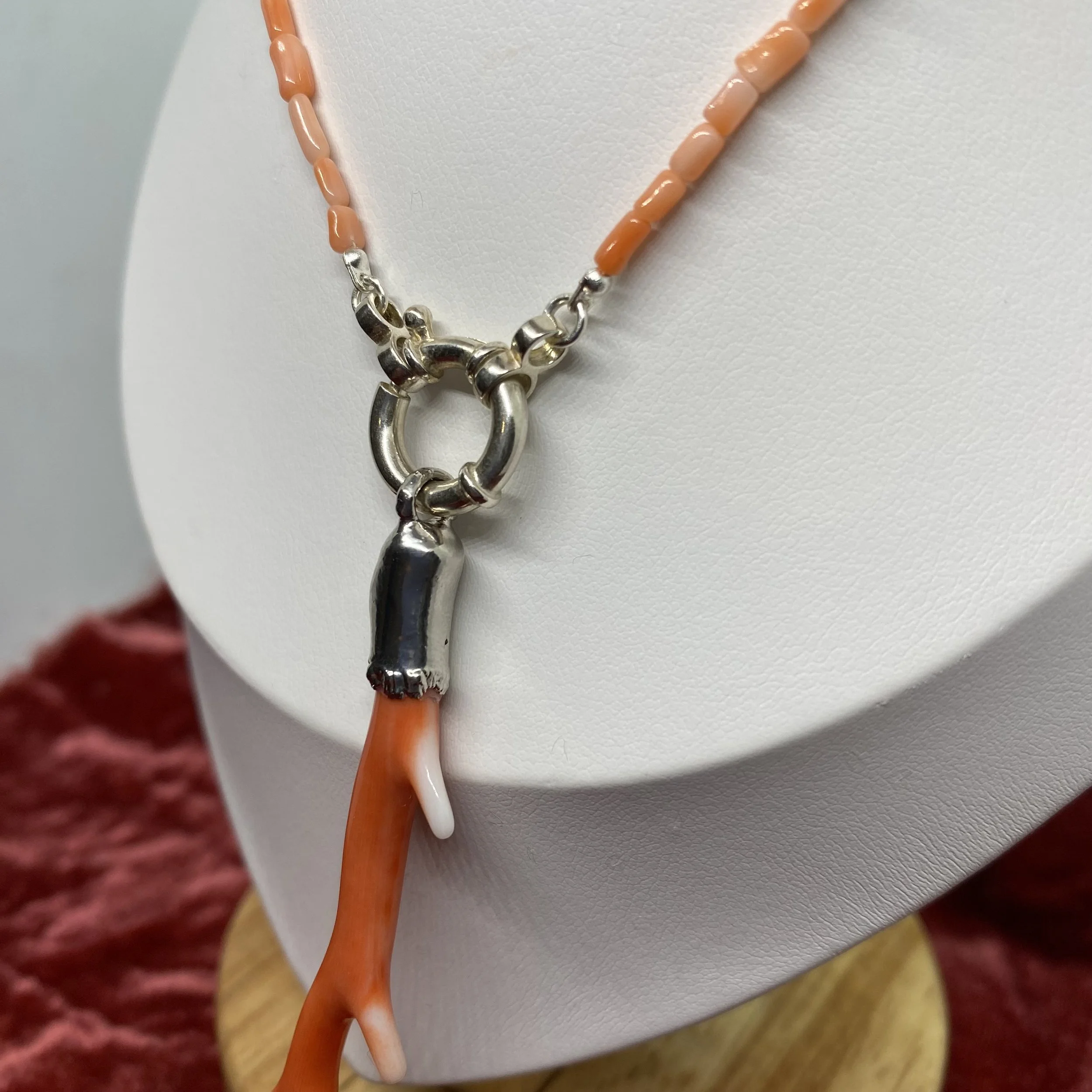 close up side shot of bolt ring clasp, coral, silver and pearl beads and deep sea coral branch pendant