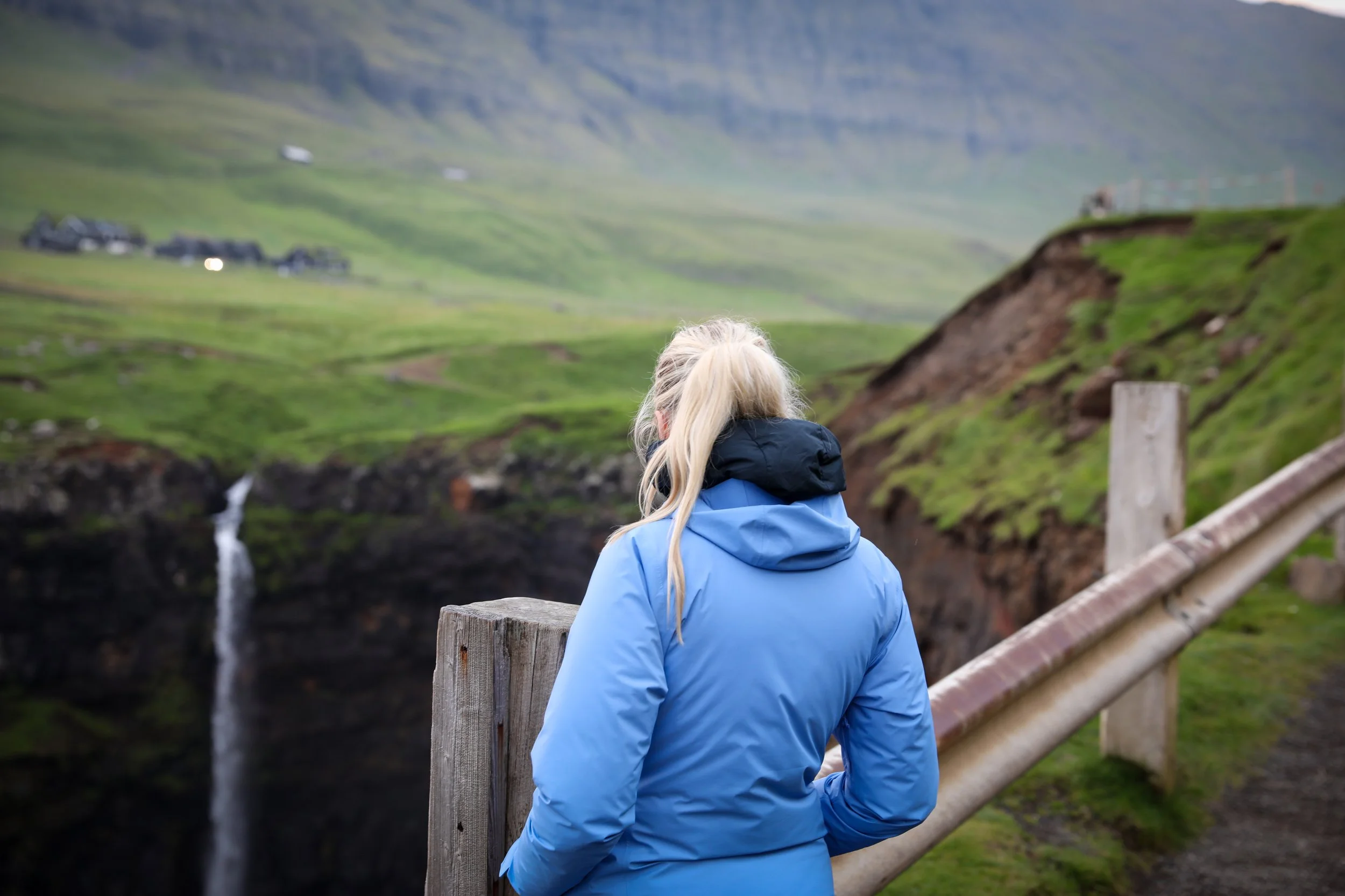 Múlafossur Waterfall person standing looking