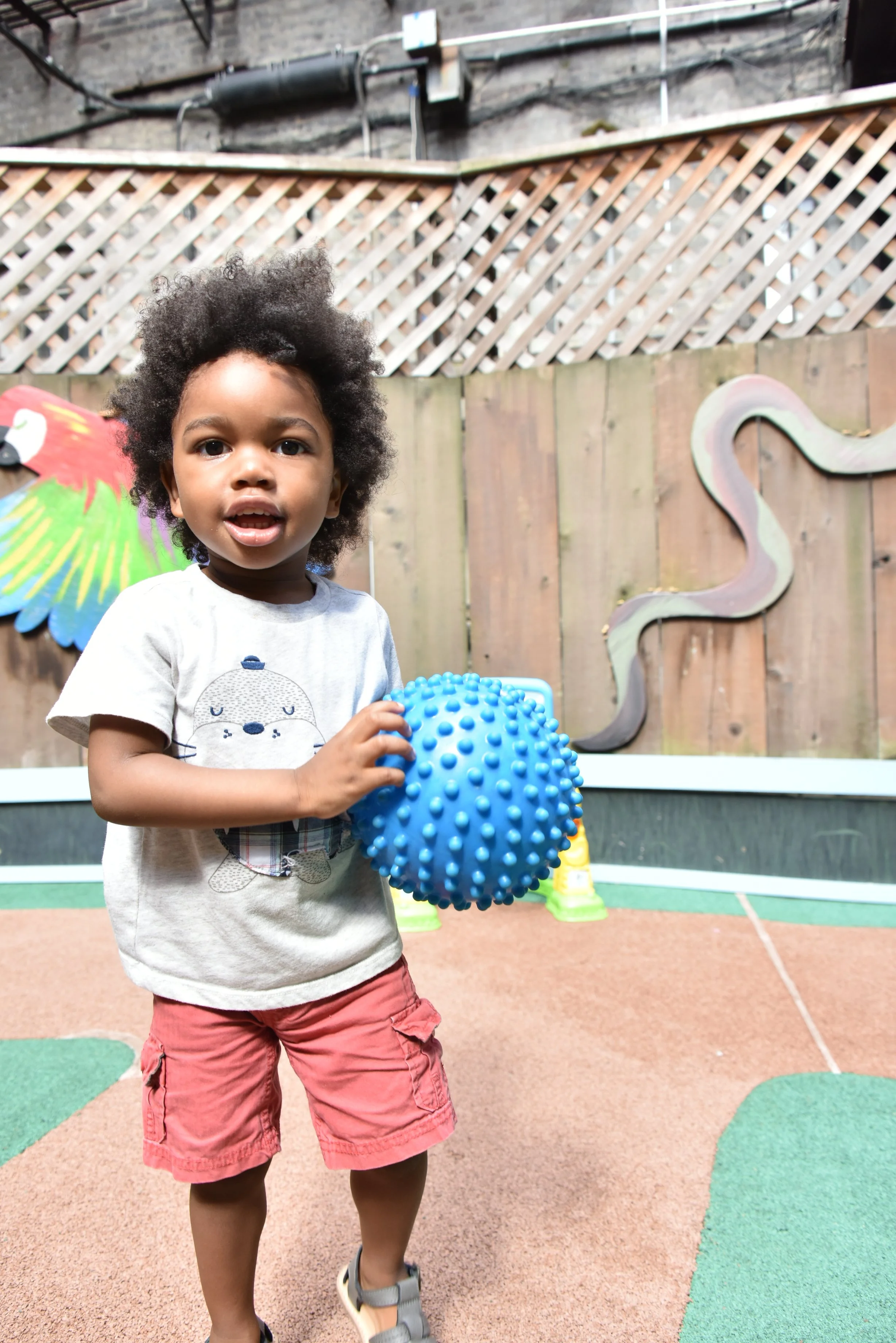 A boy holding a blue ball