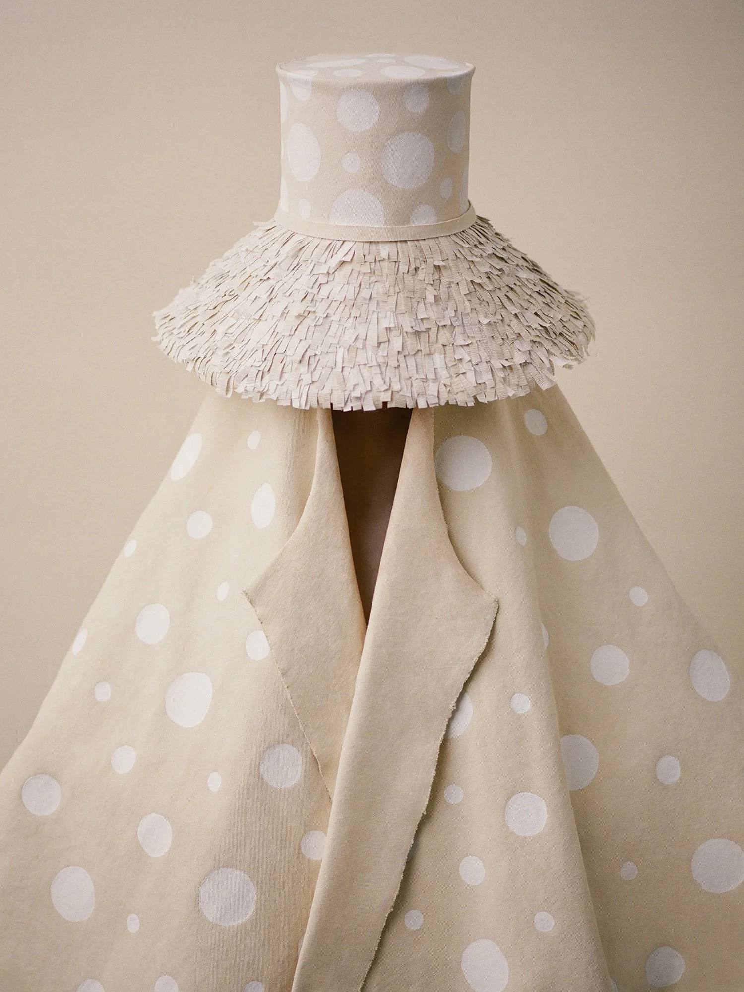 A conceptual portrait exploring repetition, texture, and form through handcrafted garments and soft neutral tones.