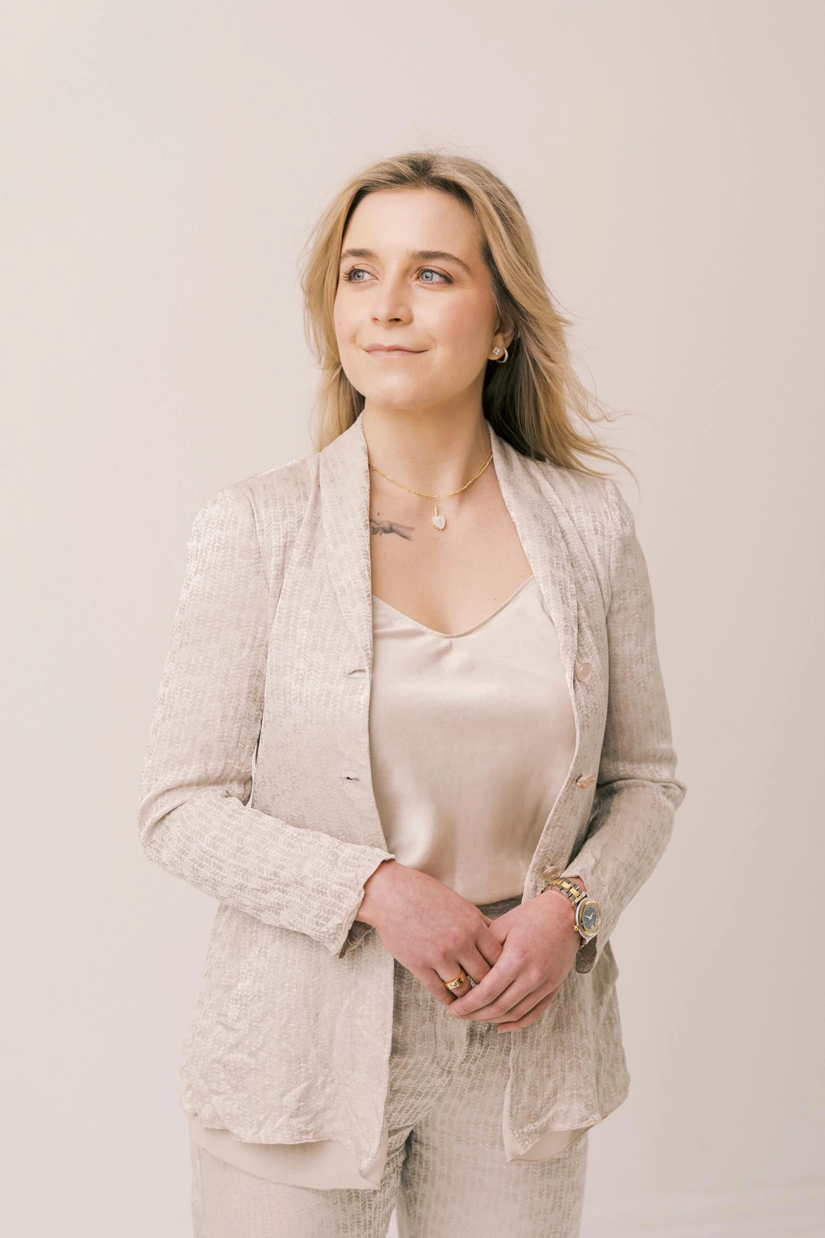 Soft, natural headshot of a woman in a light textured suit, photographed in a timeless studio style