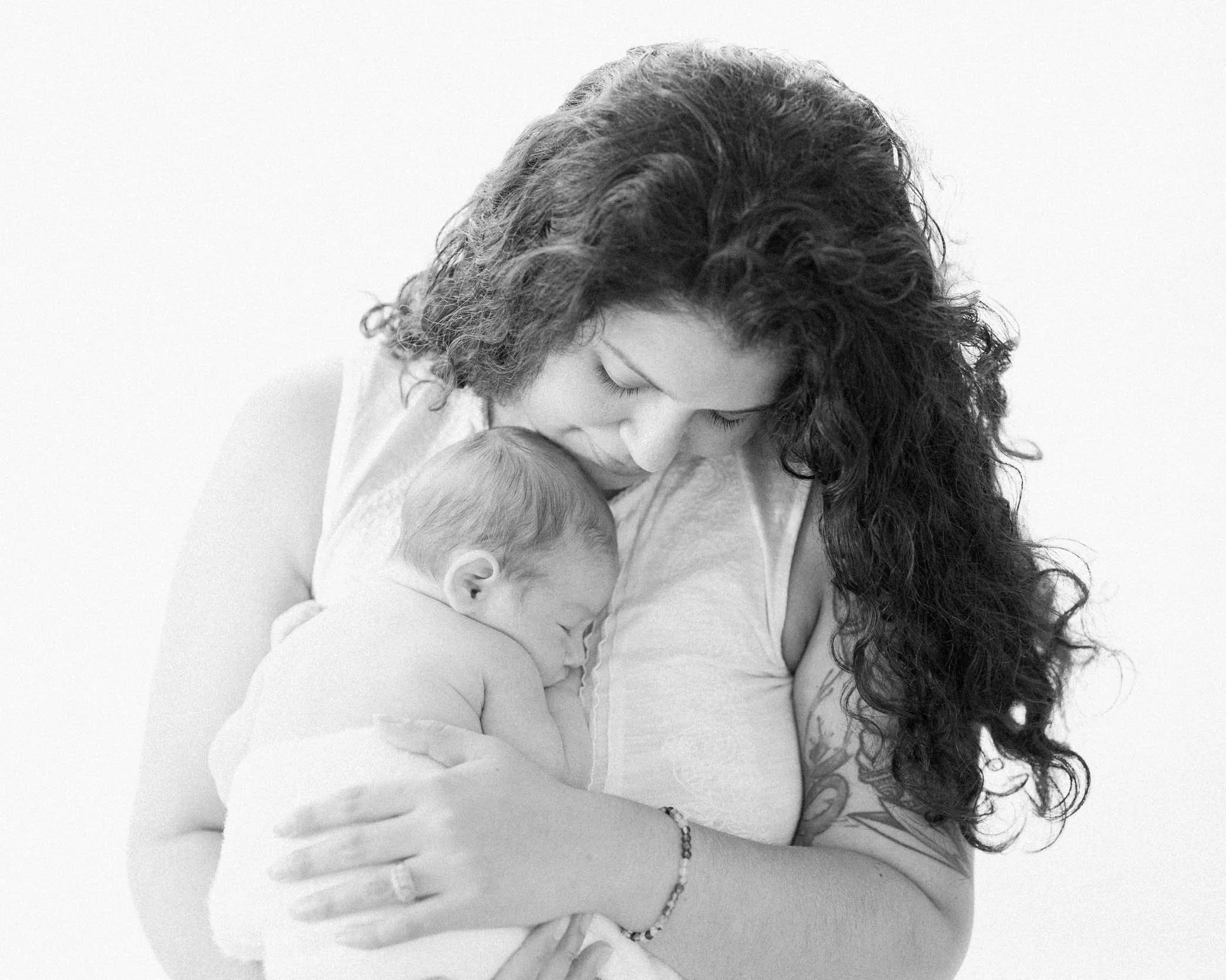 Mom holding her sleeping newborn baby during a photography session in Charlotte, NC