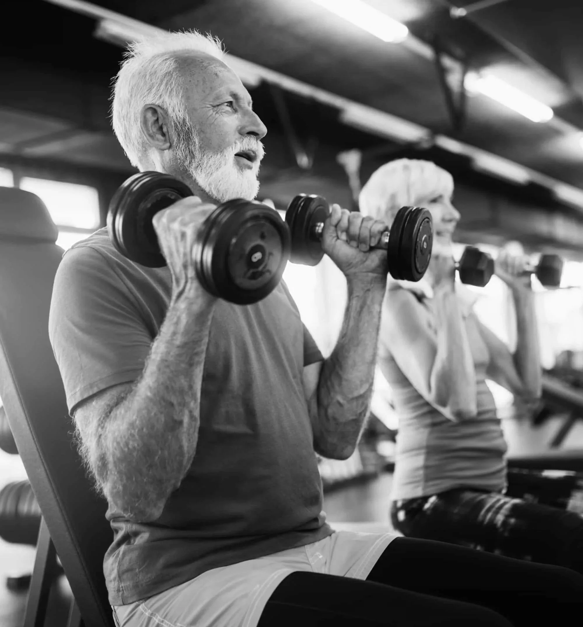 Two seniors doing weight training with dumbbells