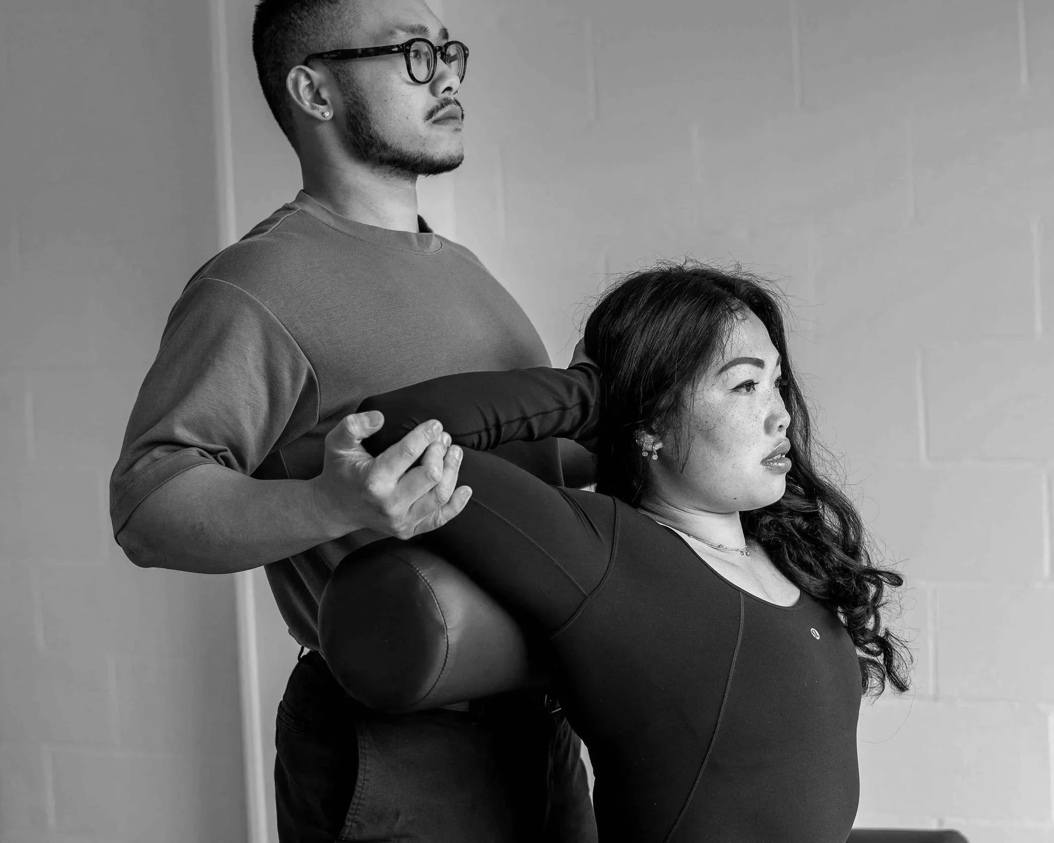Therapist hold his client elbows to retract her shoulder in assisted stretching