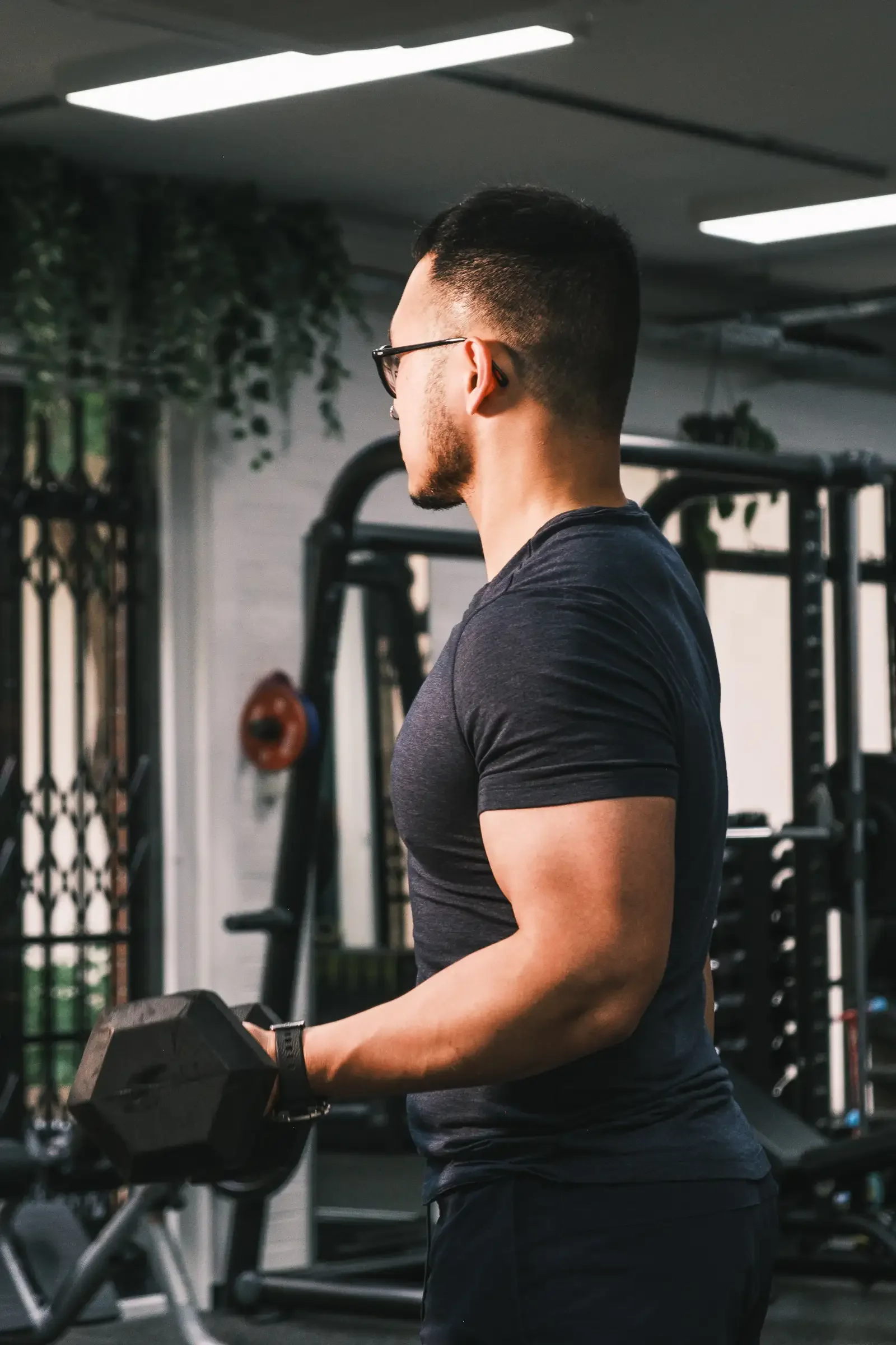 Alexander, head and shoulders, in the studio. Doing bicep curls.