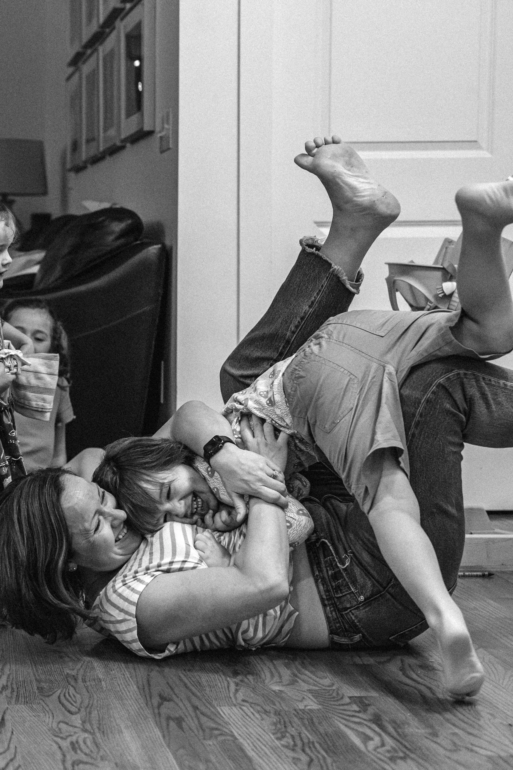 Mom wrestling her son on the floor of the living room
