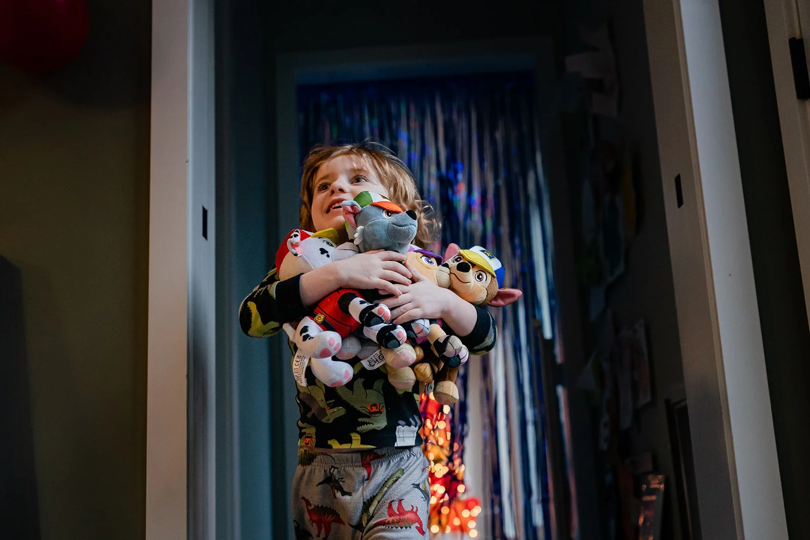 Little boy holding an arm full of stuffed animals