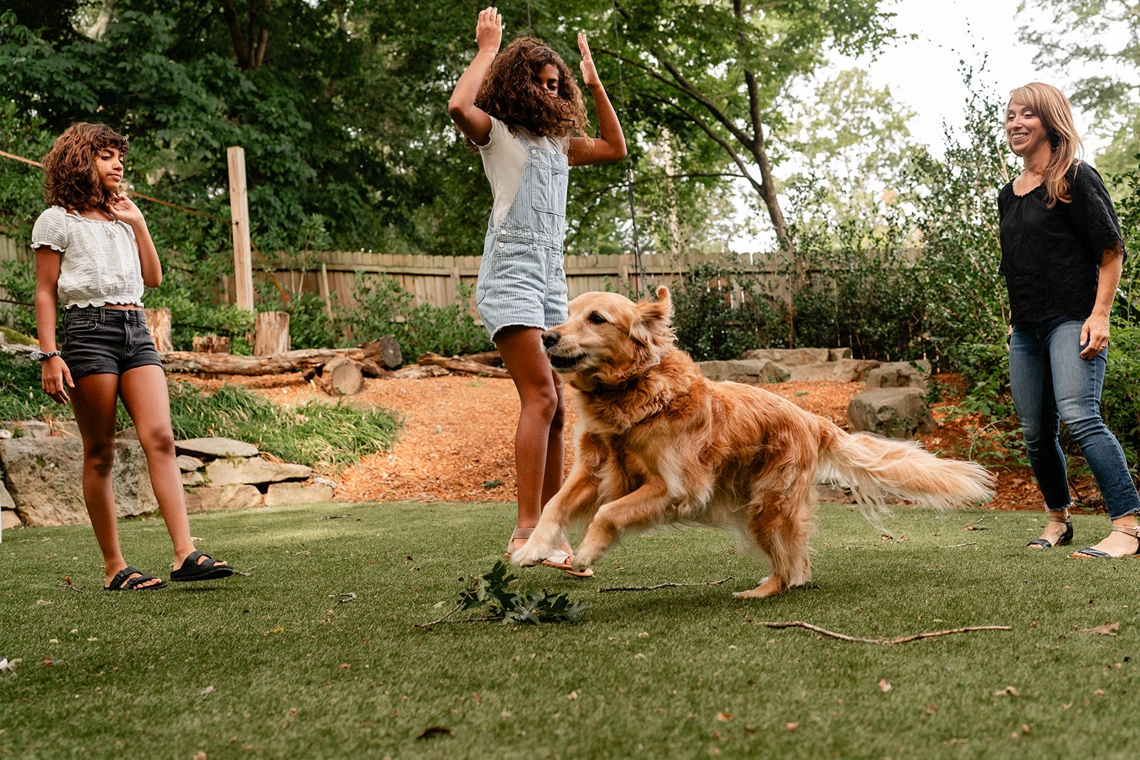Family playing with their dog in the backyard