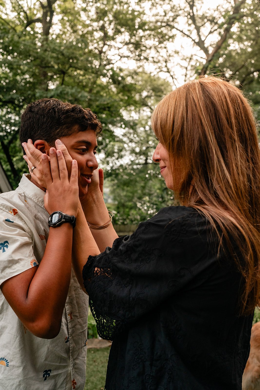 Mom holding her teenage son's cheeks