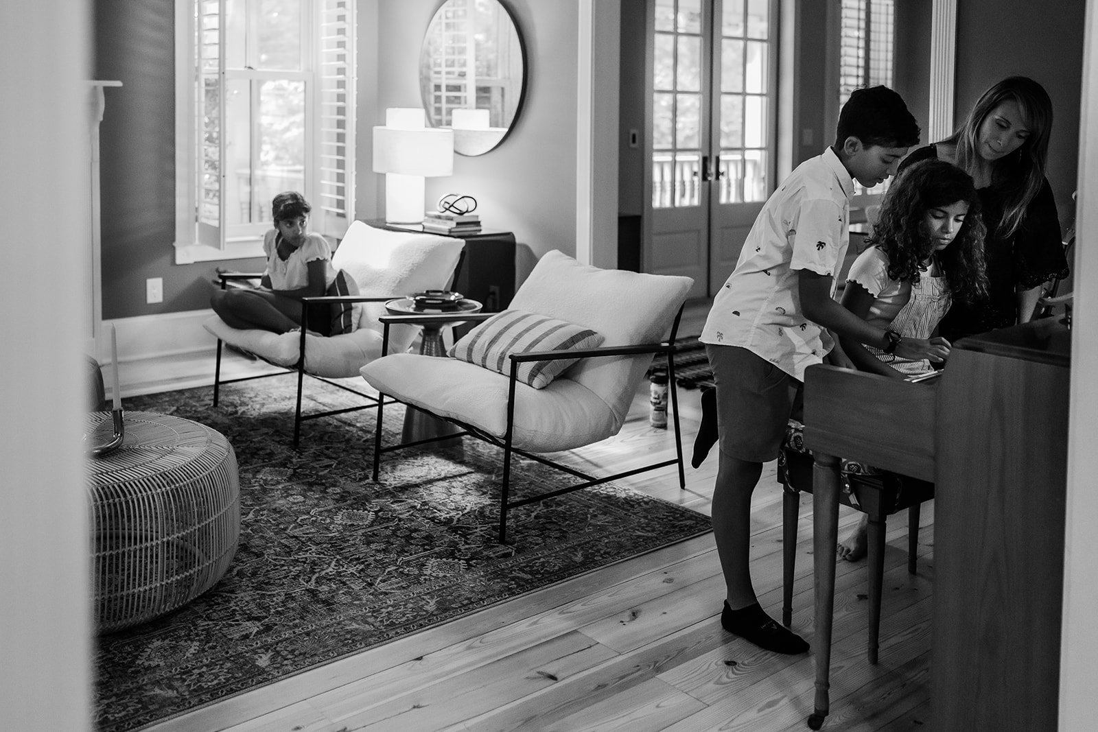 Family in living room while some kids play piano